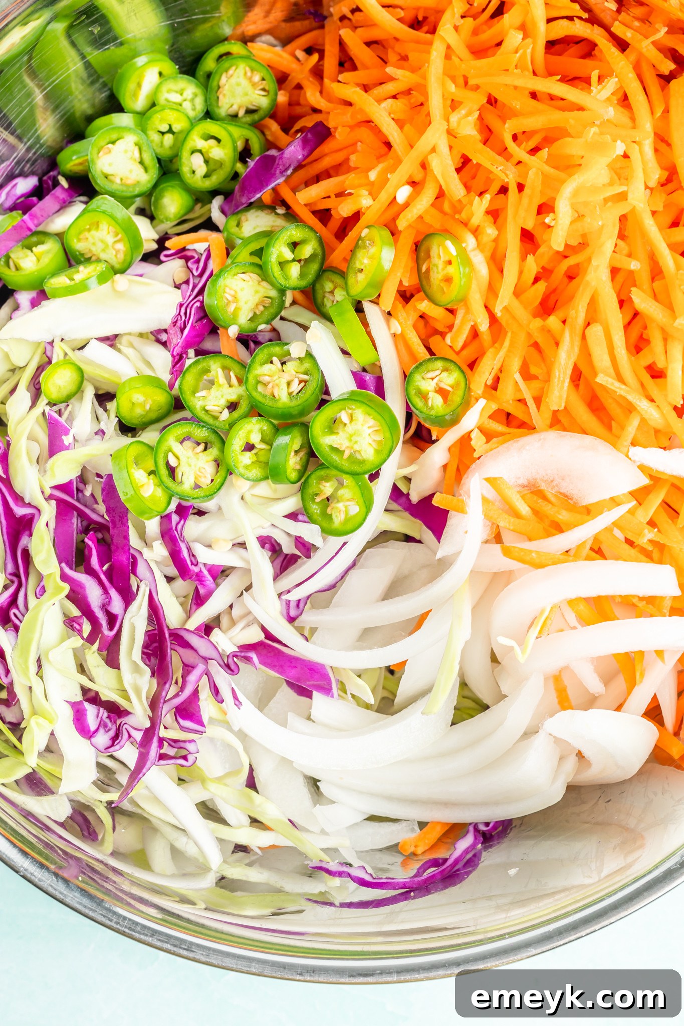 Prepared shredded vegetables for Easy Curtido Recipe, including cabbage, carrots, and onions, in a large mixing bowl, ready for the next step.
