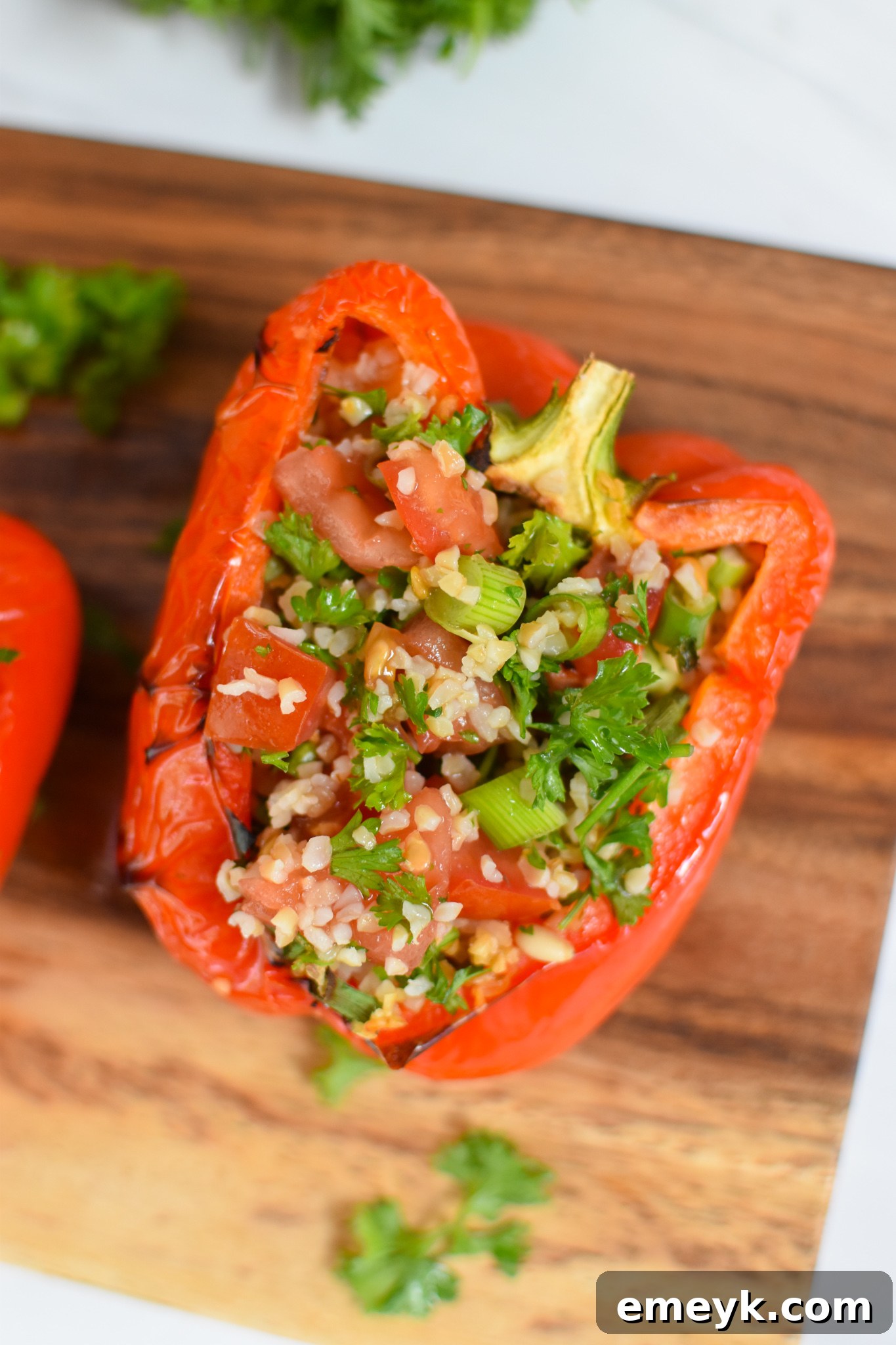 Fresh bell peppers sliced in half on a cutting board, ready for stuffing in a Vegan Stuffed Peppers Recipe.