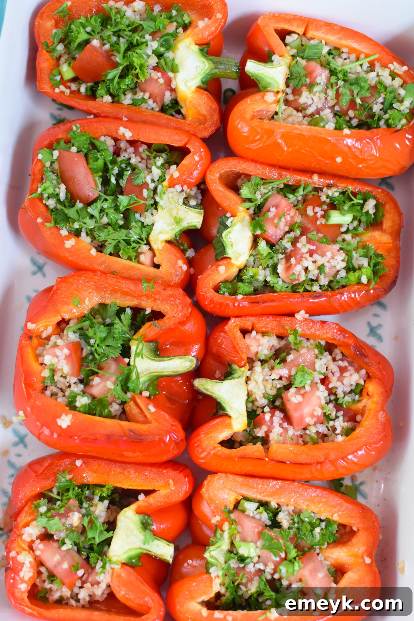 Tabbouleh-filled bell peppers arranged in a baking dish, ready for their final bake.