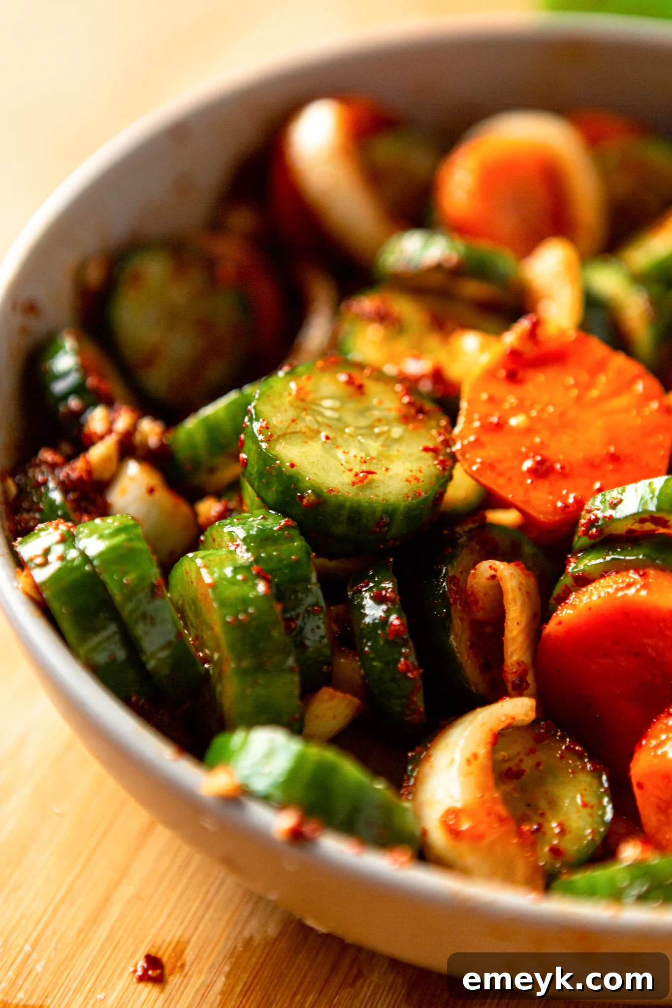 Quick Korean Cucumber Kimchi in a white bowl, garnished with toasted sesame seeds, ready for serving.