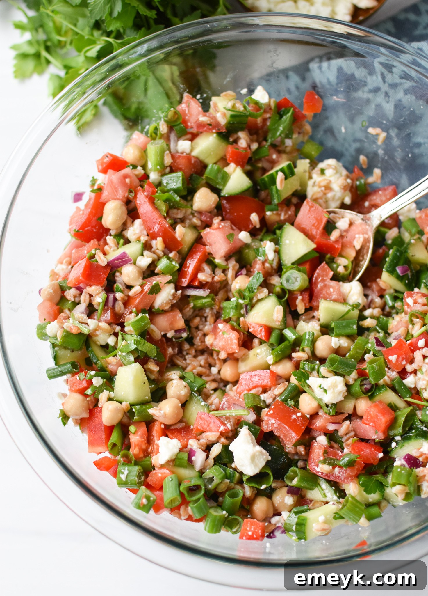 Close-up of Mediterranean Farro Salad in a clear bowl, highlighting the fresh ingredients.