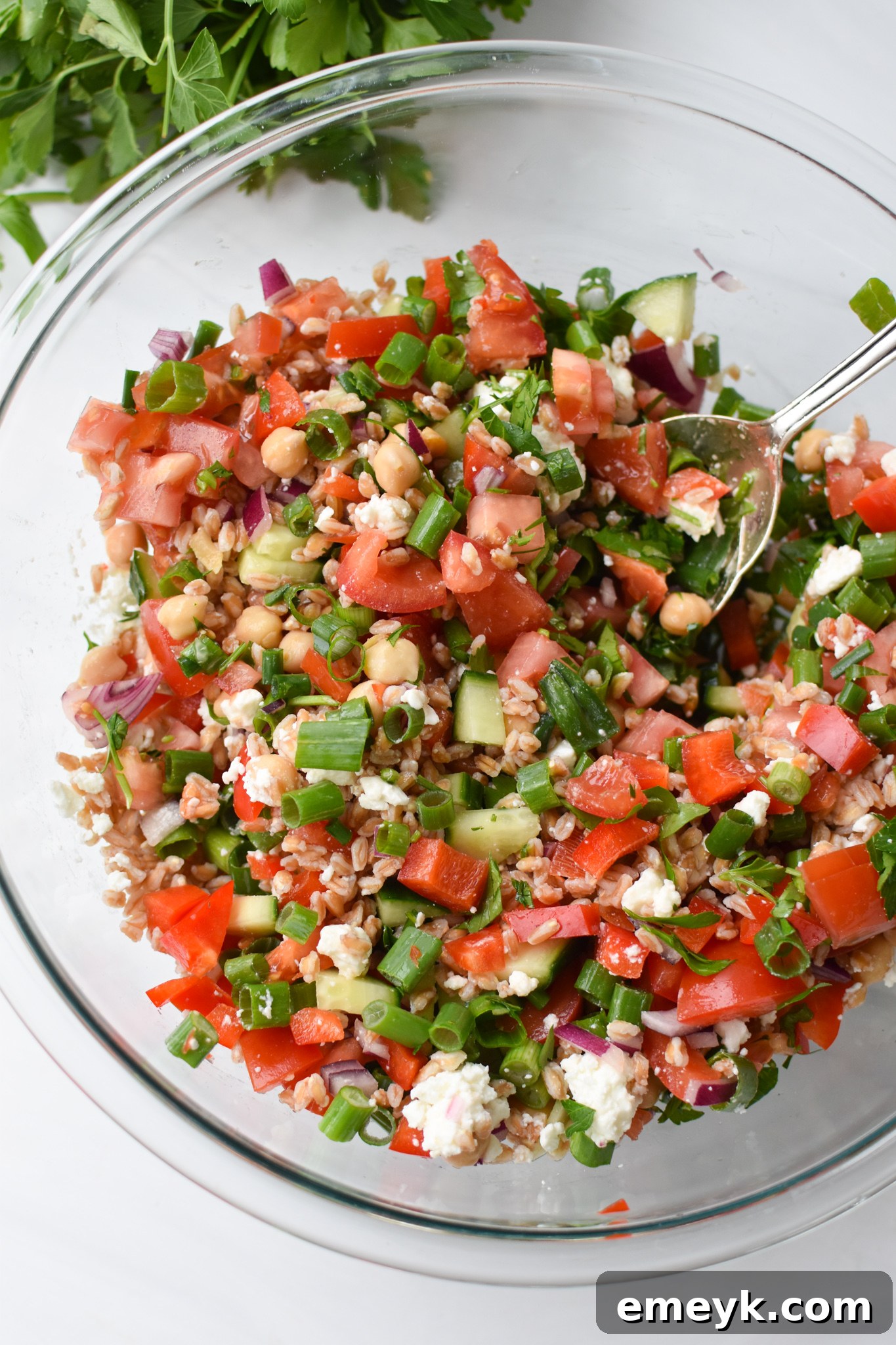 Mediterranean Farro Salad being scooped with a spoon, showing its texture and ingredients.
