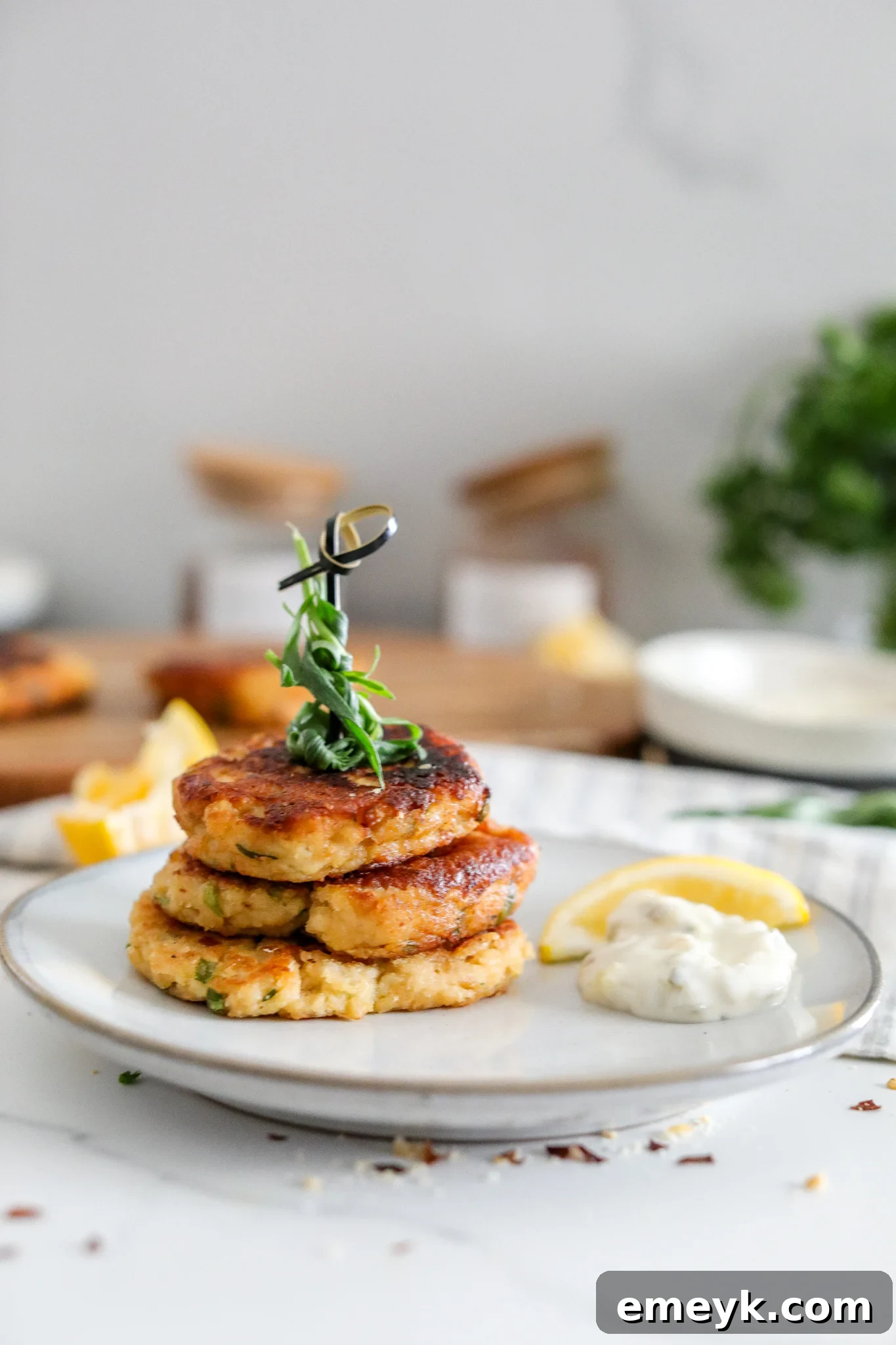 Delicious Easy Crab Cake Recipe with creamy tartar sauce, garnished with fresh herbs and lemon wedges.