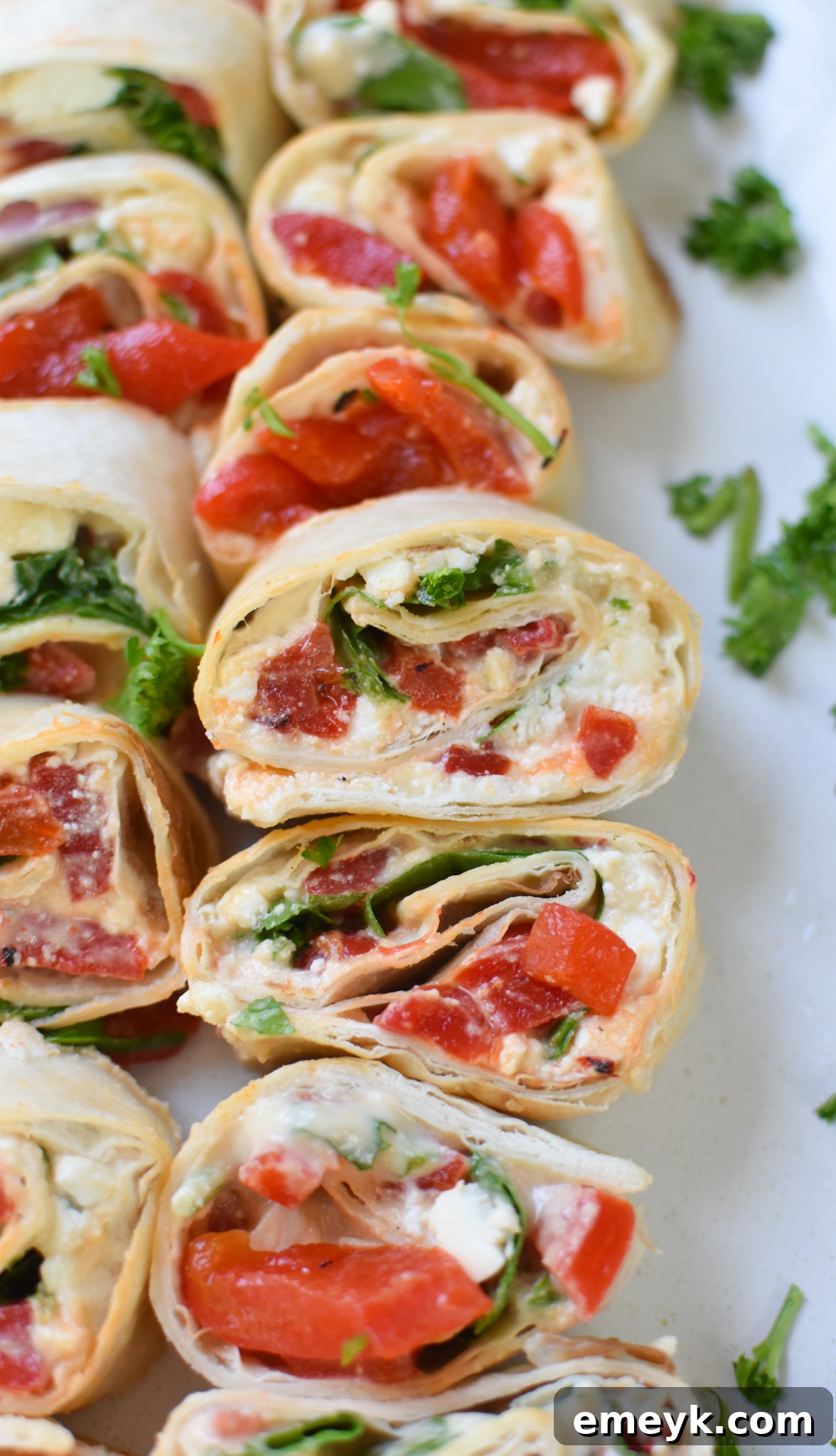 A platter of freshly made Mediterranean Pinwheels, neatly sliced and arranged, ready for serving.