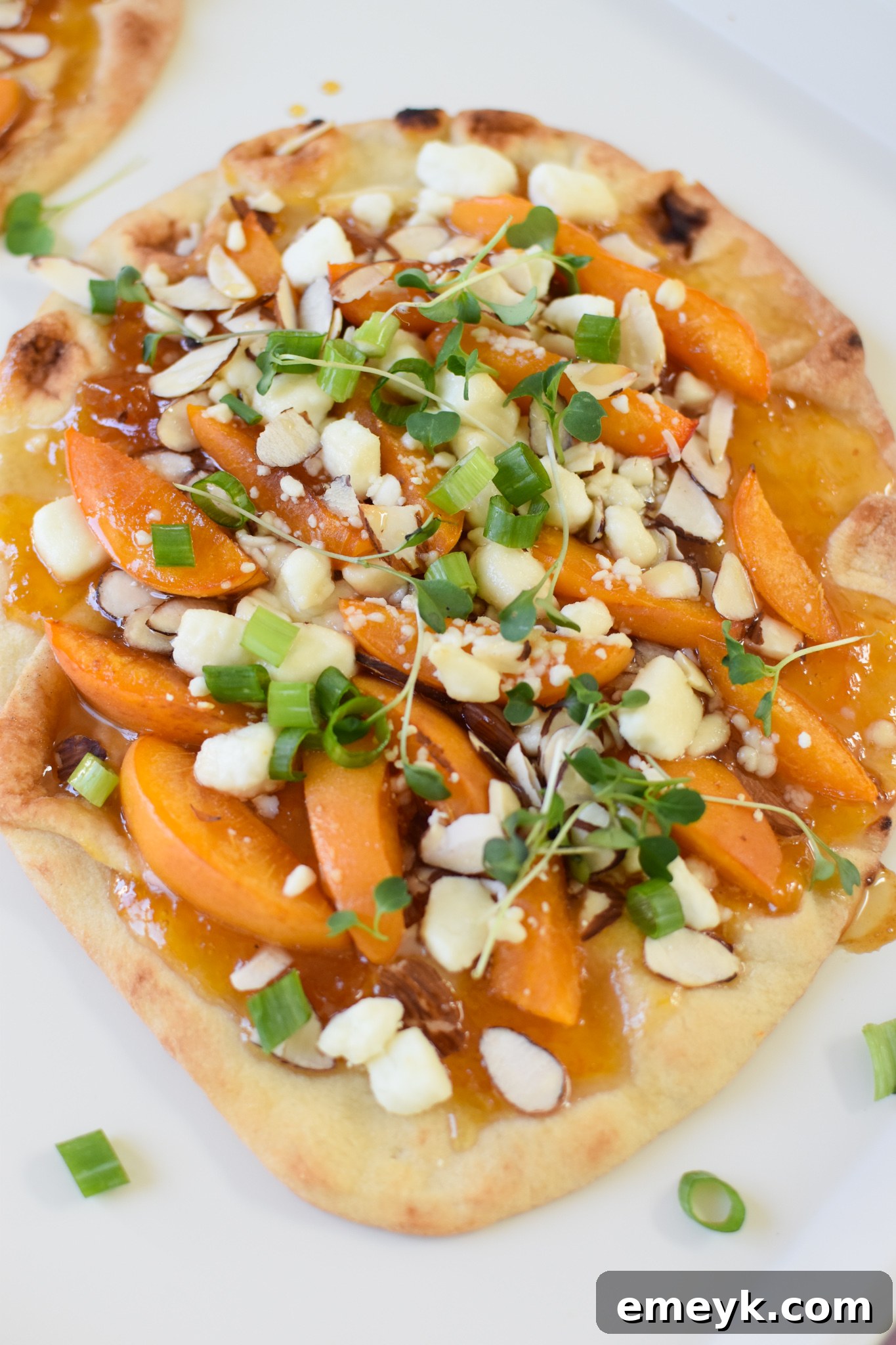 Golden Apricot & Chèvre Pizza 2 Delicious Goat Cheese Apricot Pizza on a white plate, garnished with microgreens.