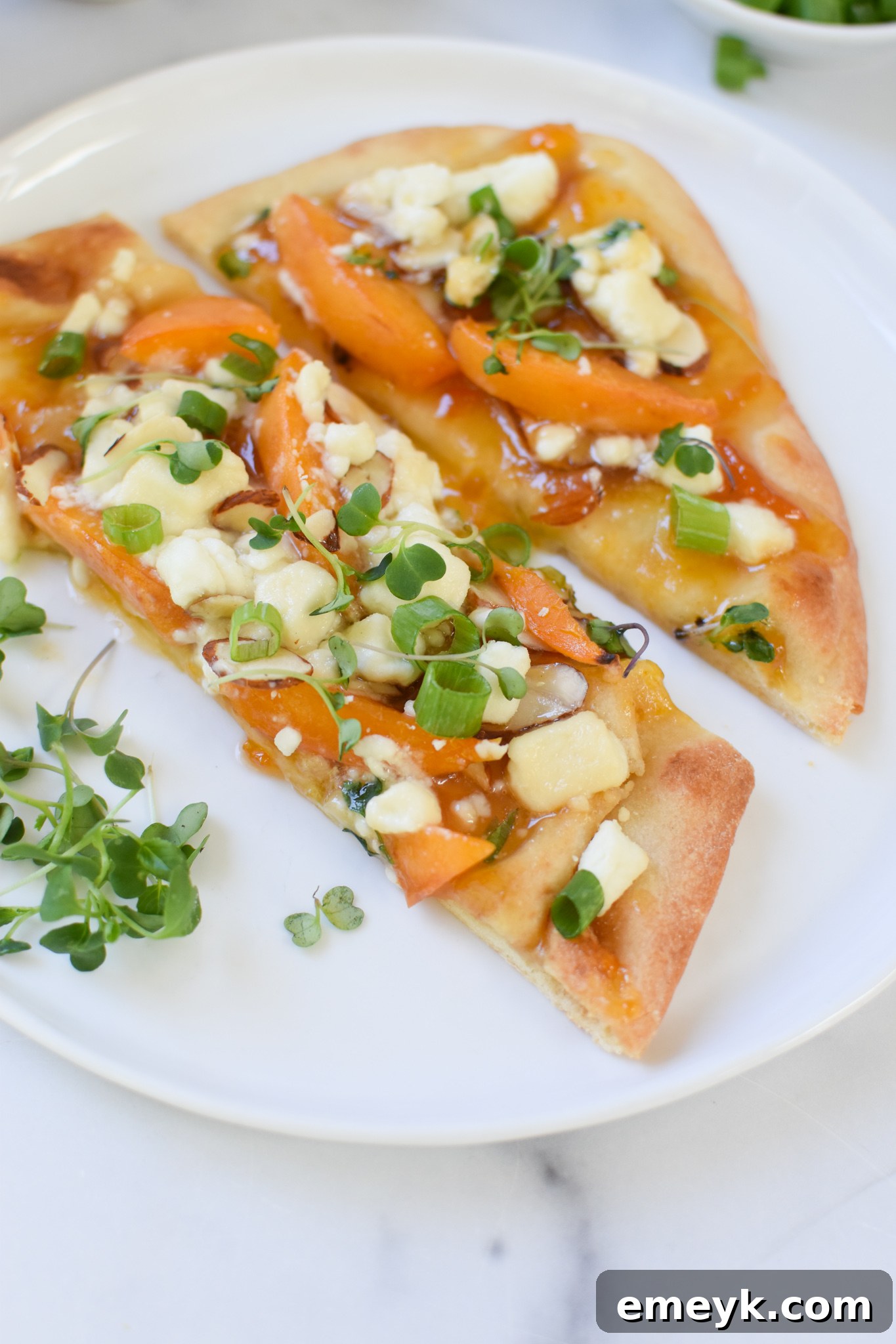Golden Apricot & Chèvre Pizza 4 Goat Cheese Apricot Pizza slices arranged neatly on a white plate, ready to be served.