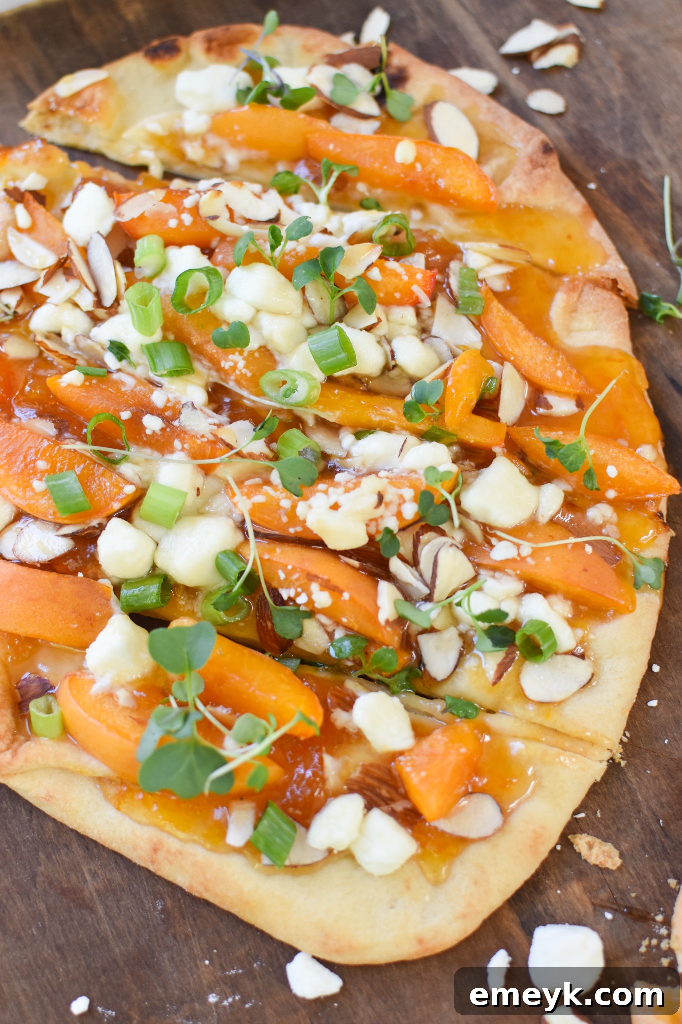 Golden Apricot & Chèvre Pizza 5 Goat Cheese Apricot Pizza on a wooden cutting board, freshly sliced and ready to serve.