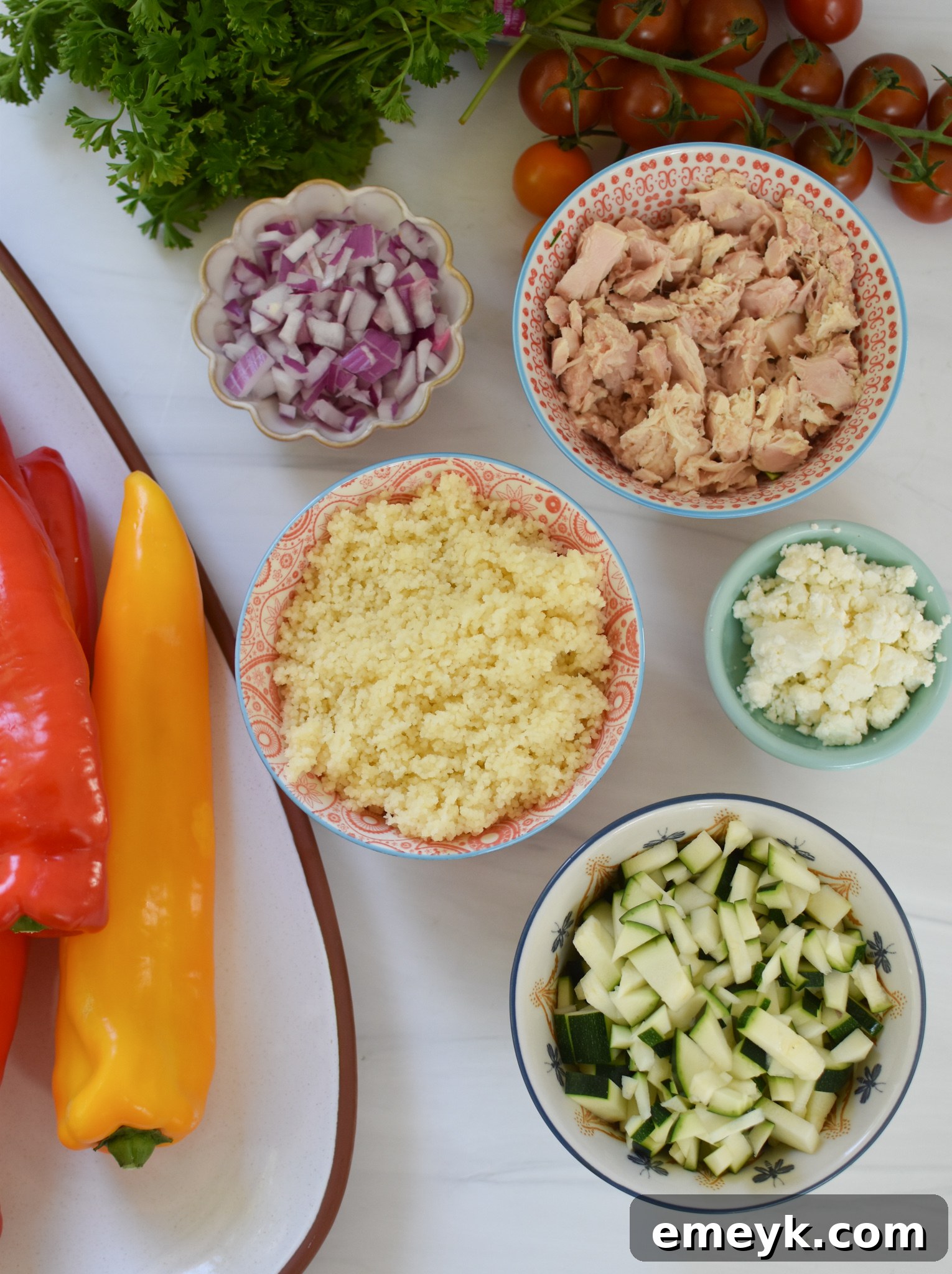 Ingredients for Mediterranean Tuna Couscous Stuffed Peppers laid out on a table.