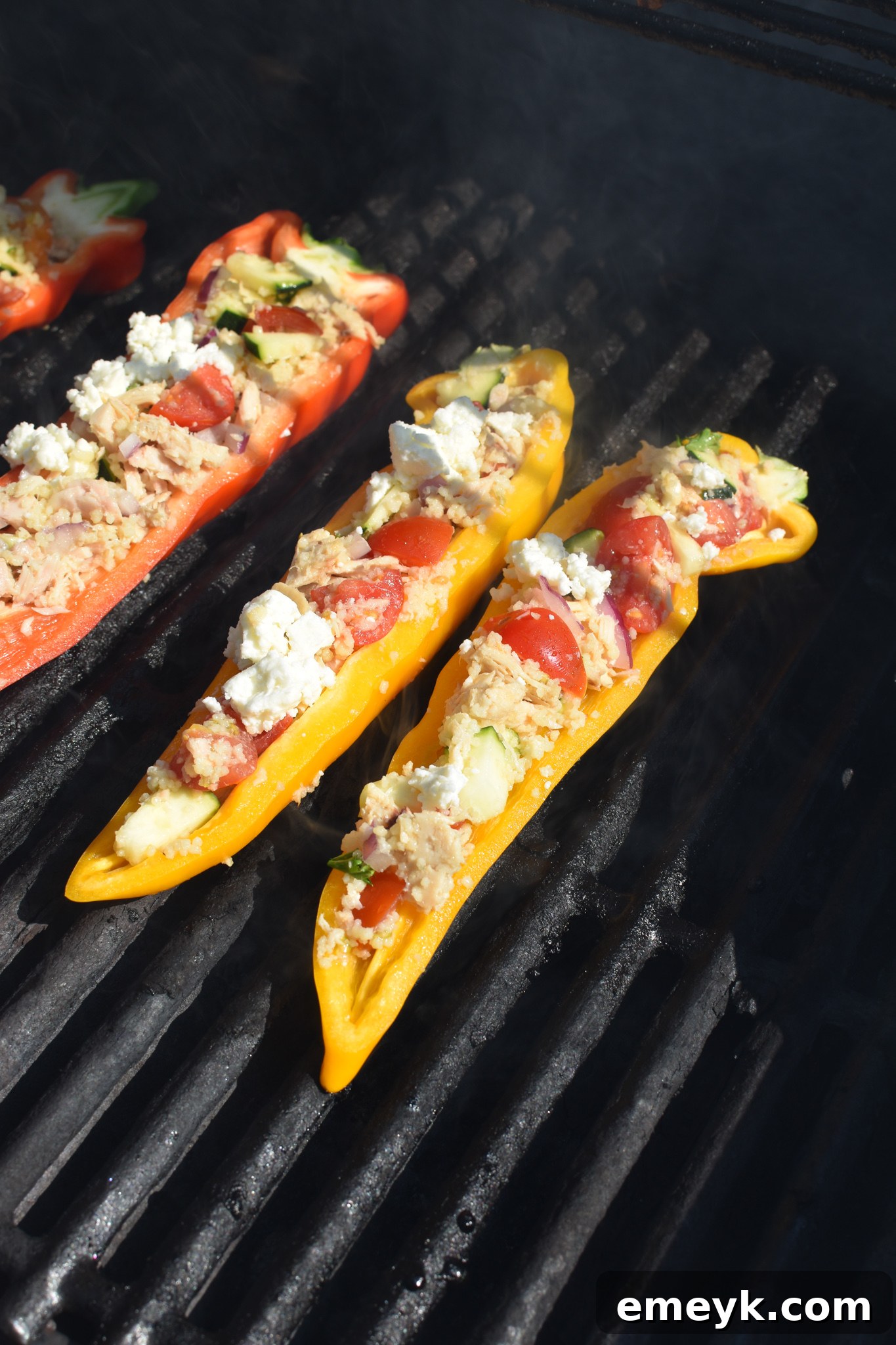 Mediterranean Tuna Couscous Stuffed Peppers grilling on an outdoor grill.