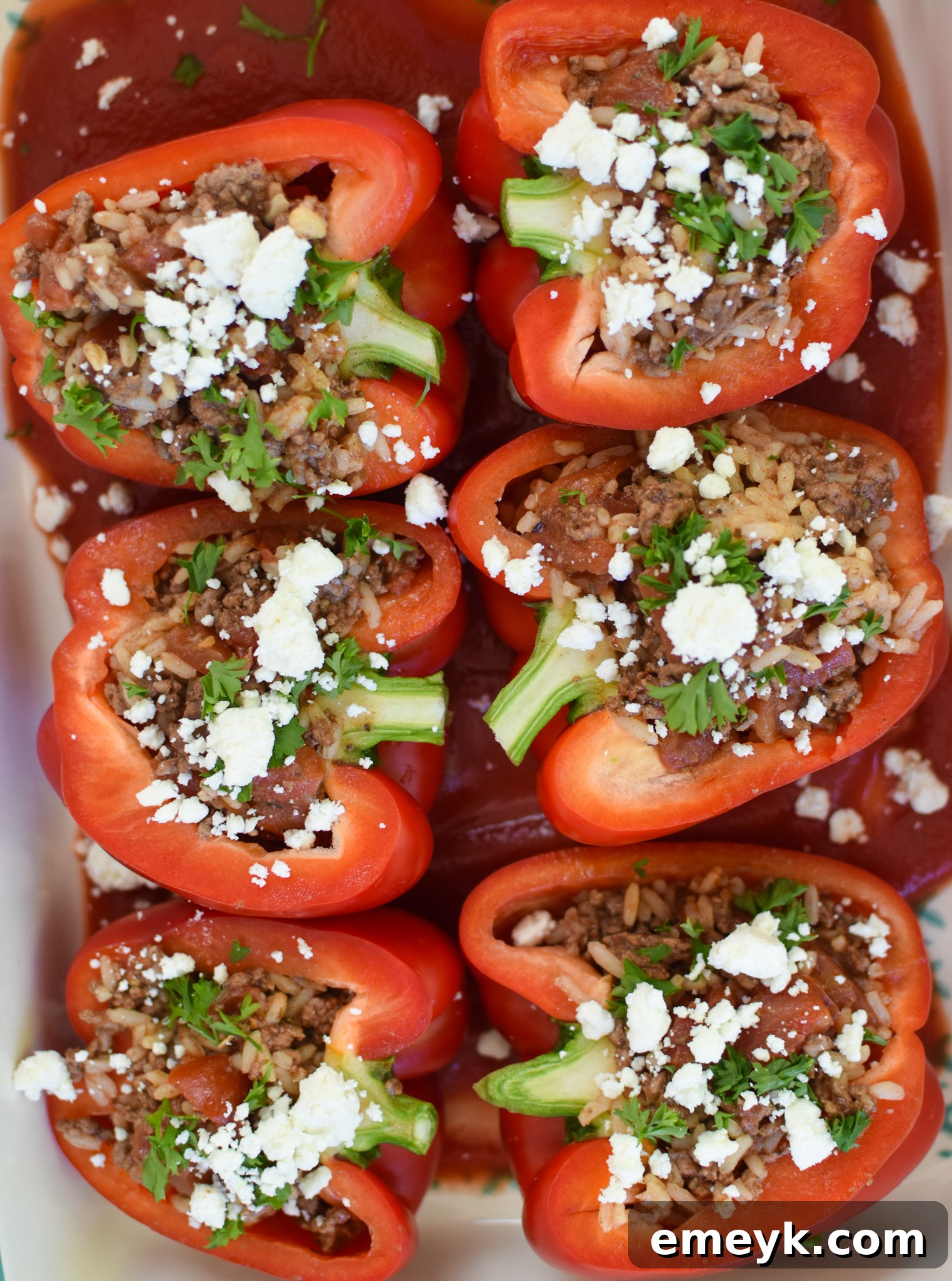 Hearty Mediterranean Beef Stuffed Peppers 10 Mediterranean Ground Beef Stuffed Peppers baking in a dish, covered with foil.