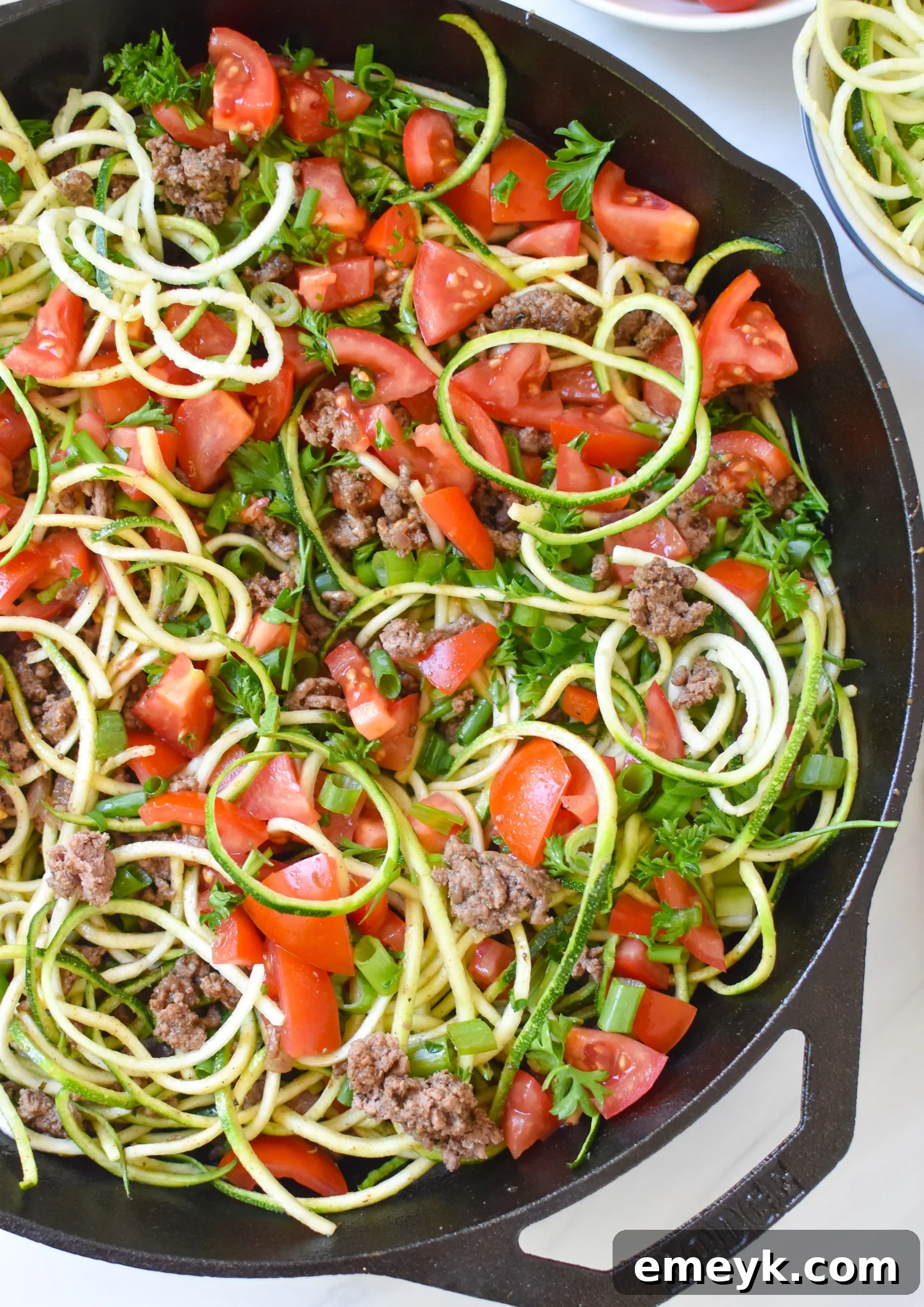 Mediterranean Ground Beef Zucchini Skillet simmering in a cast iron skillet, showcasing its rich colors and appetizing texture.