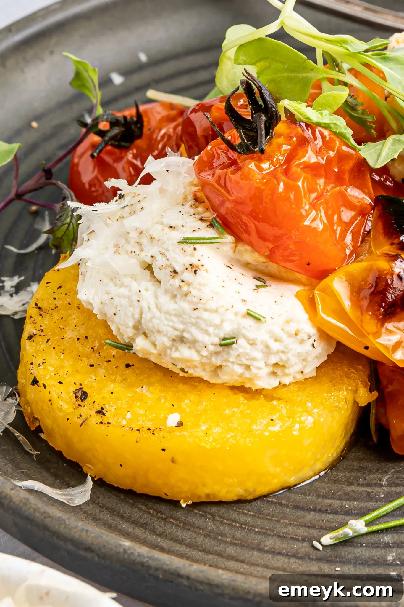 Crispy Polenta Stacks with ricotta cheese and roasted cherry tomatoes on a serving platter.