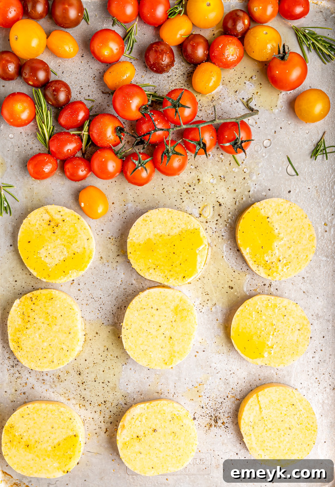 Crispy Polenta Stacks and roasted tomatoes on a baking sheet, golden and tender, fresh out of the oven.
