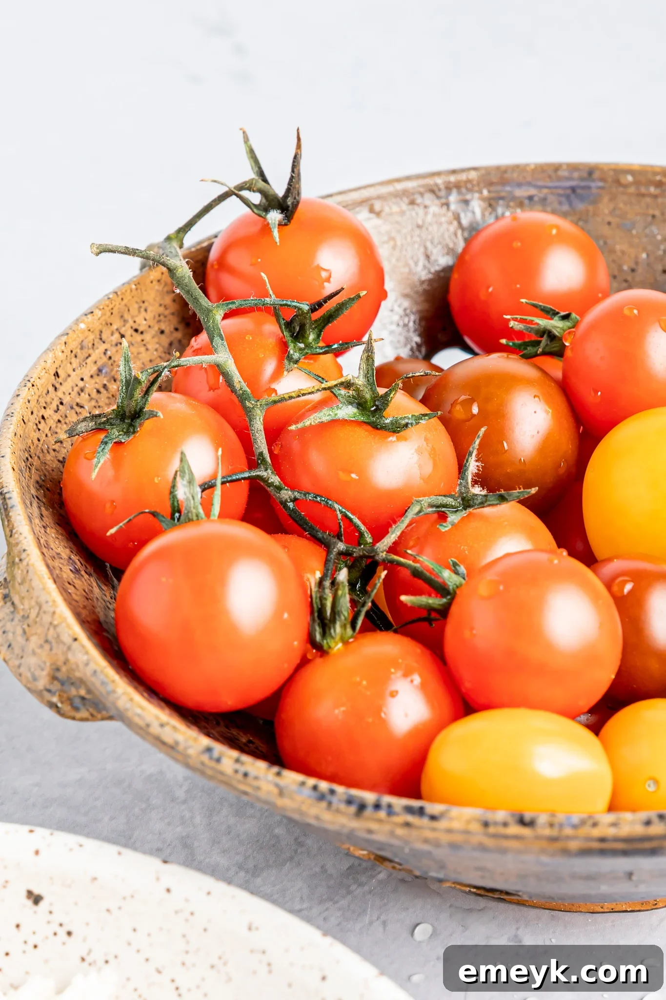 Close-up of roasted cherry tomatoes, vibrant and soft from the oven.