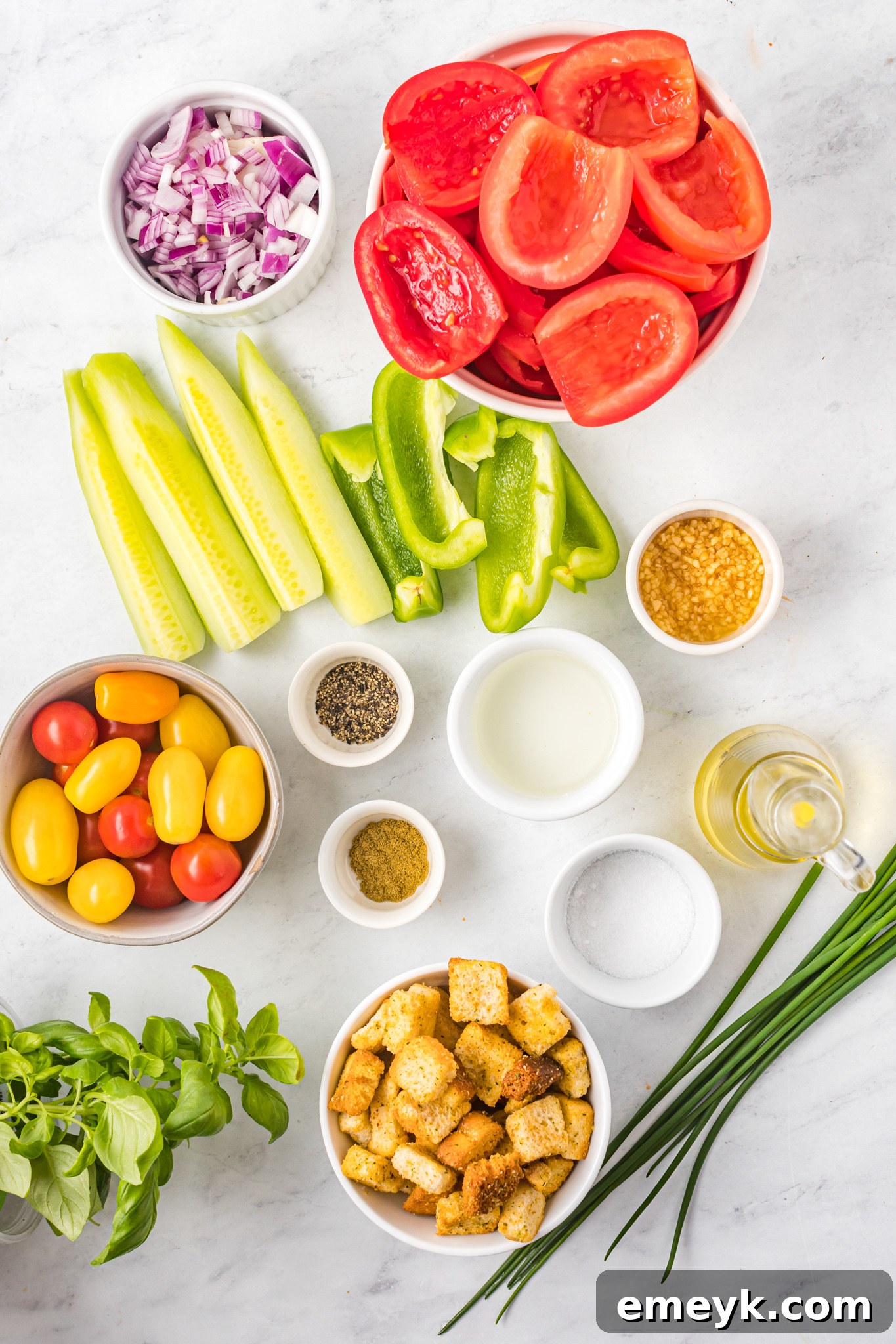 Selection of fresh ingredients for Easy Gazpacho Recipe, including tomatoes, cucumbers, bell peppers, and onion.
