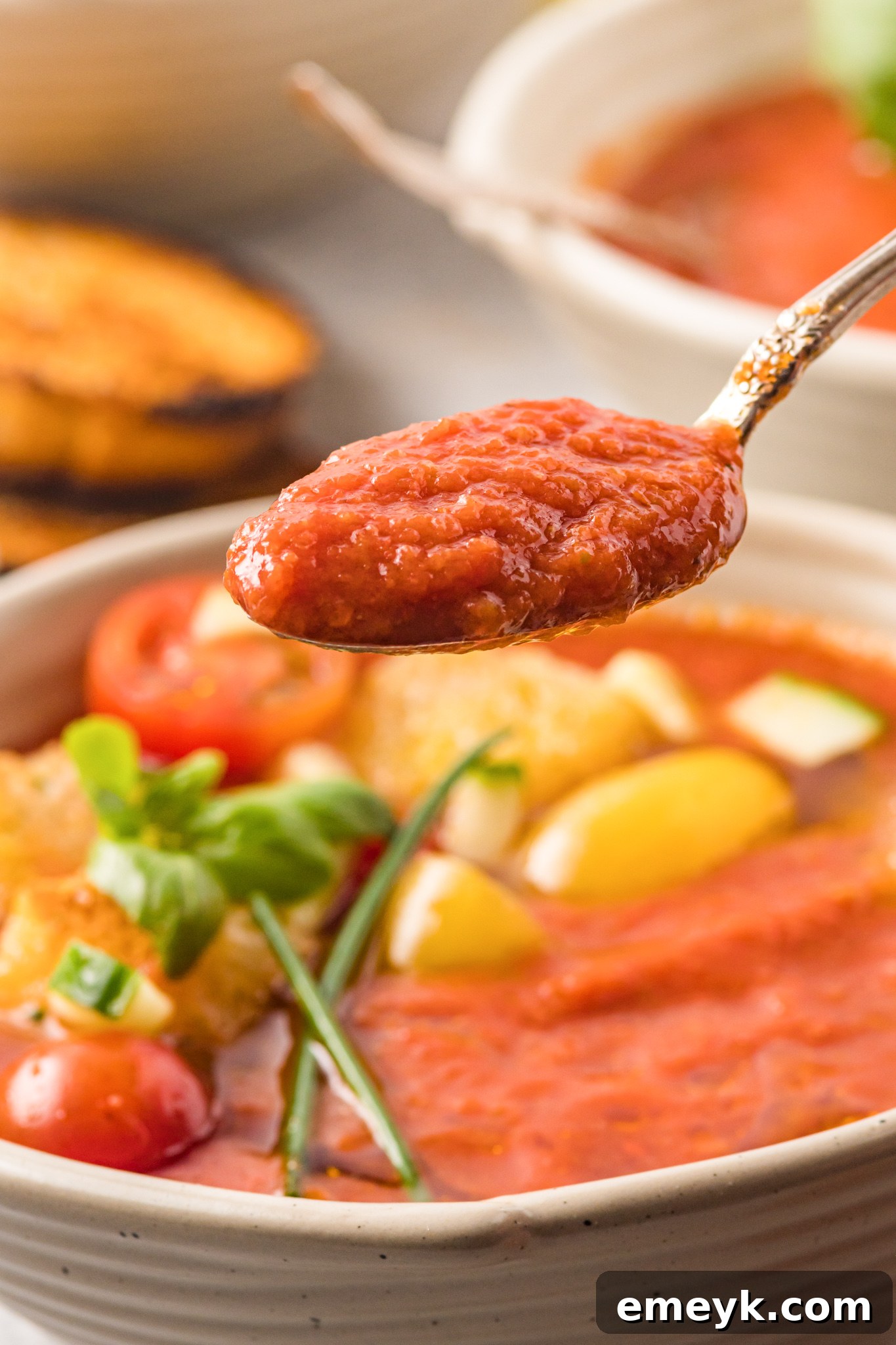 Easy Gazpacho Recipe in a bowl with a spoon, showing its smooth texture.