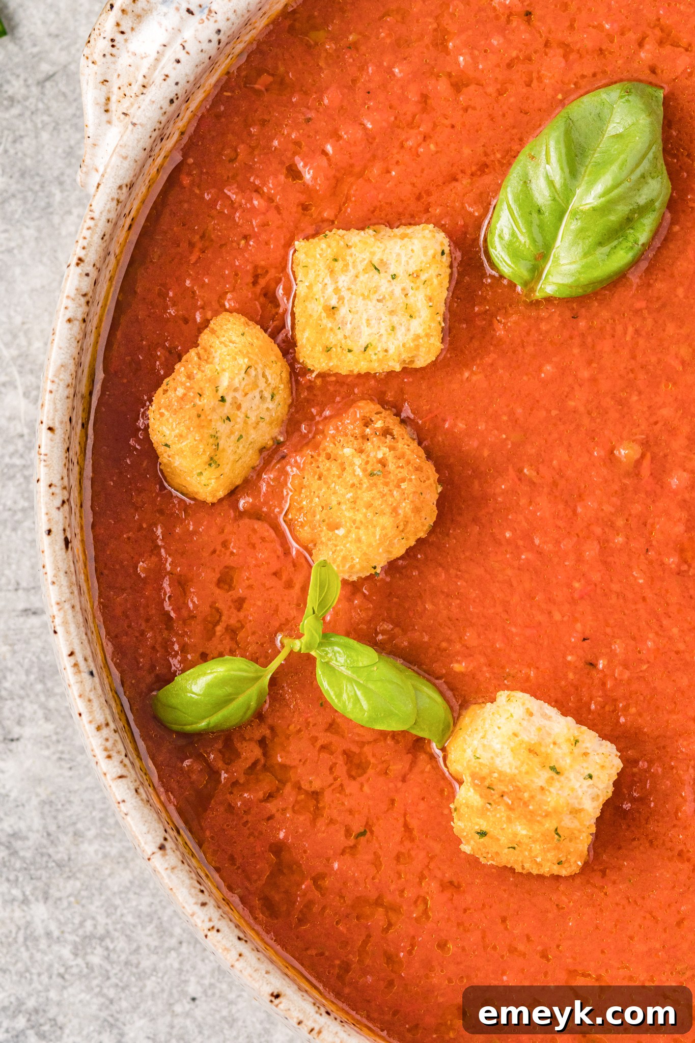 Easy Gazpacho Recipe garnished with fresh basil leaves.