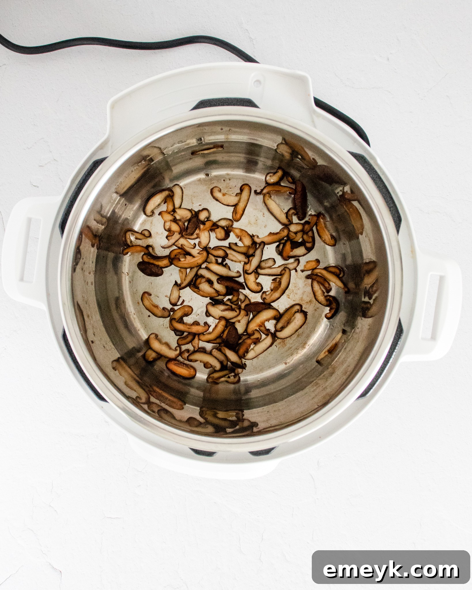 Shiitake mushrooms and shallots sautéing in an Instant Pot.
