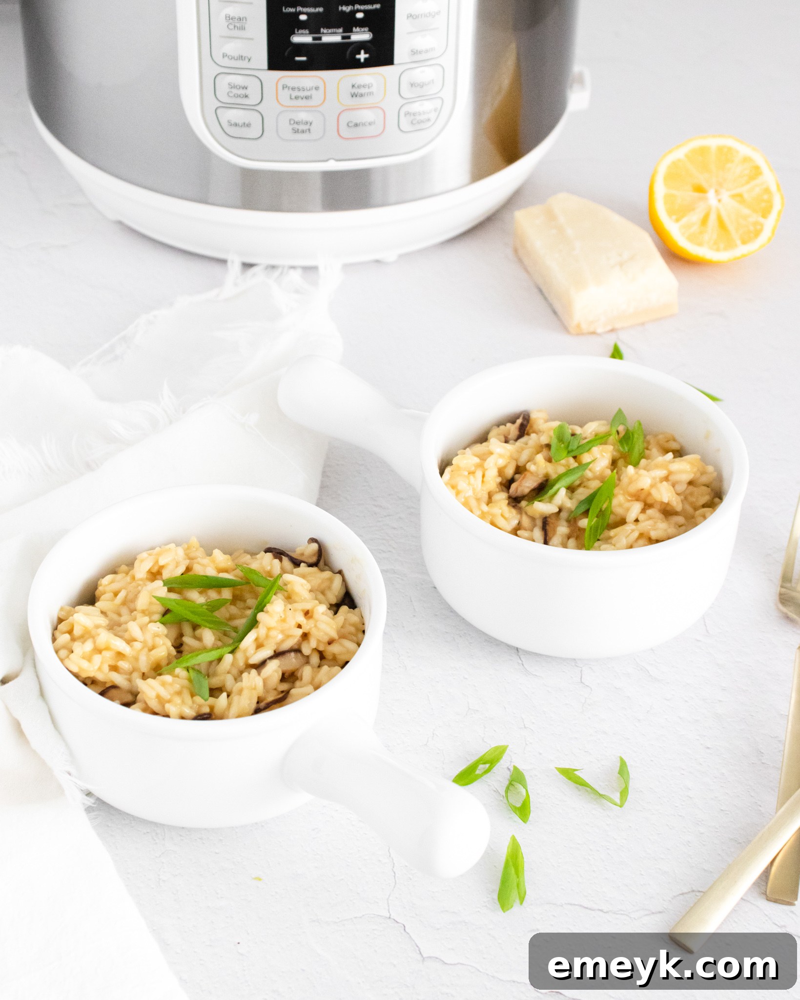 Two white bowls filled with Instant Pot Mushroom Risotto, garnished.