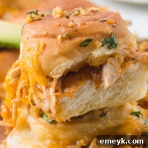Close-up of baked Chicken Enchilada Sliders, showing the melted cheese and golden buns.
