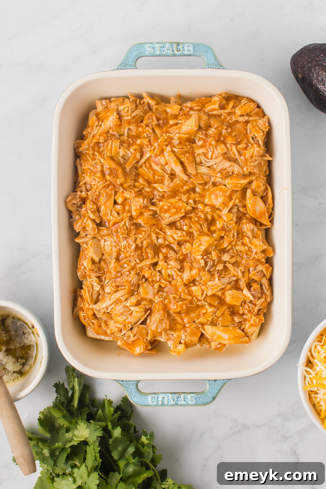 Chicken Enchilada Sliders with the seasoned chicken mixture spread over the bottom buns.