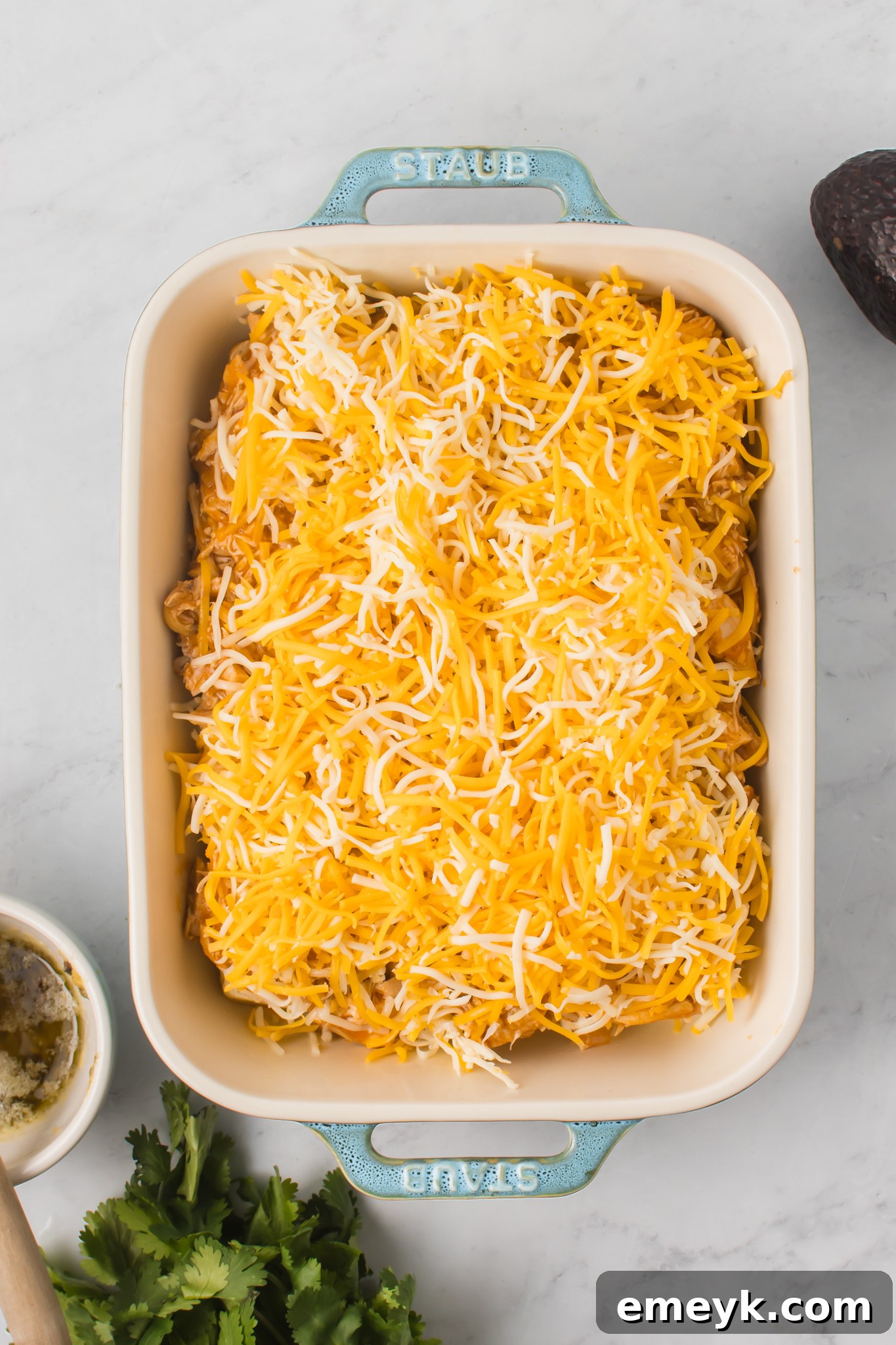 Chicken Enchilada Sliders topped with a generous layer of shredded cheese.