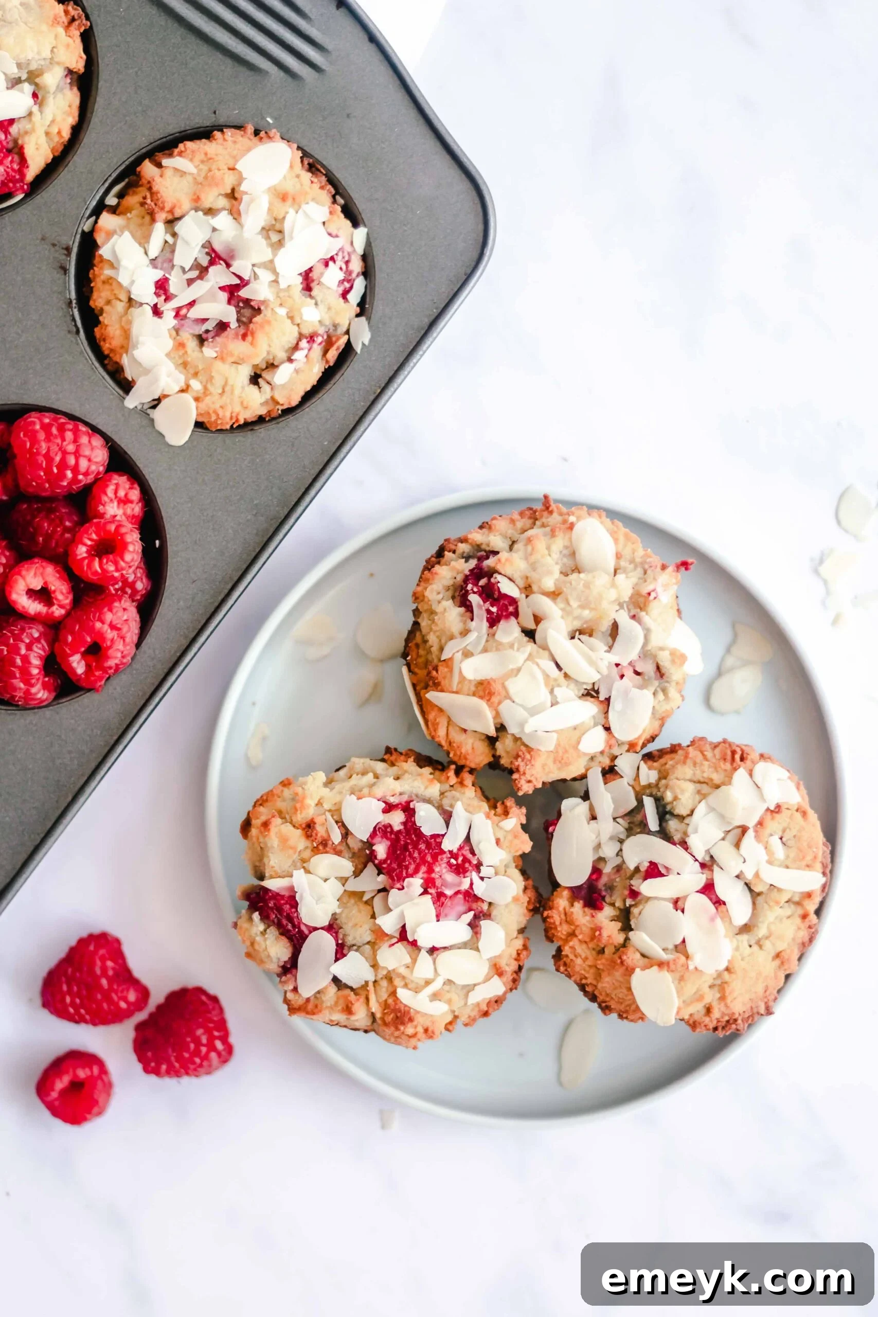 Close-up of Keto Raspberry Muffins on a white plate, showcasing the texture and fresh raspberries.