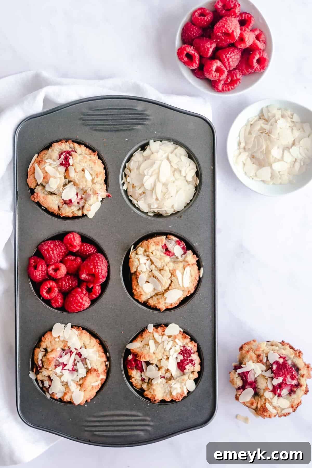 A muffin tin filled with freshly baked Keto Raspberry Muffins, ready for cooling and storage.