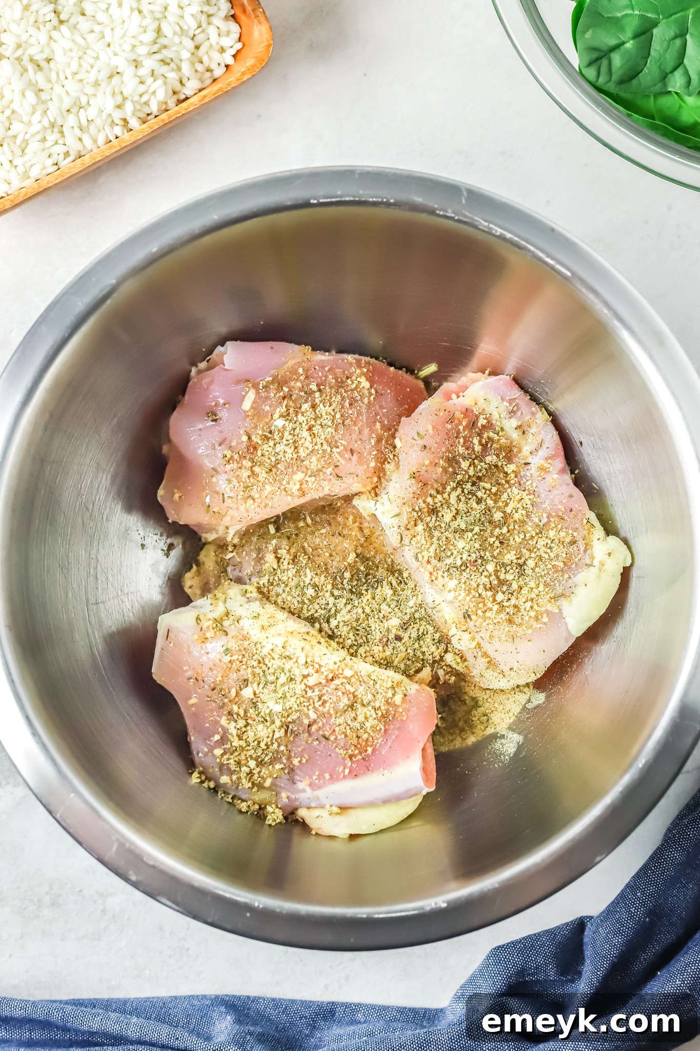Chicken thighs seasoned with spices, ready for searing, for Oven Baked Chicken Thighs with Risotto.
