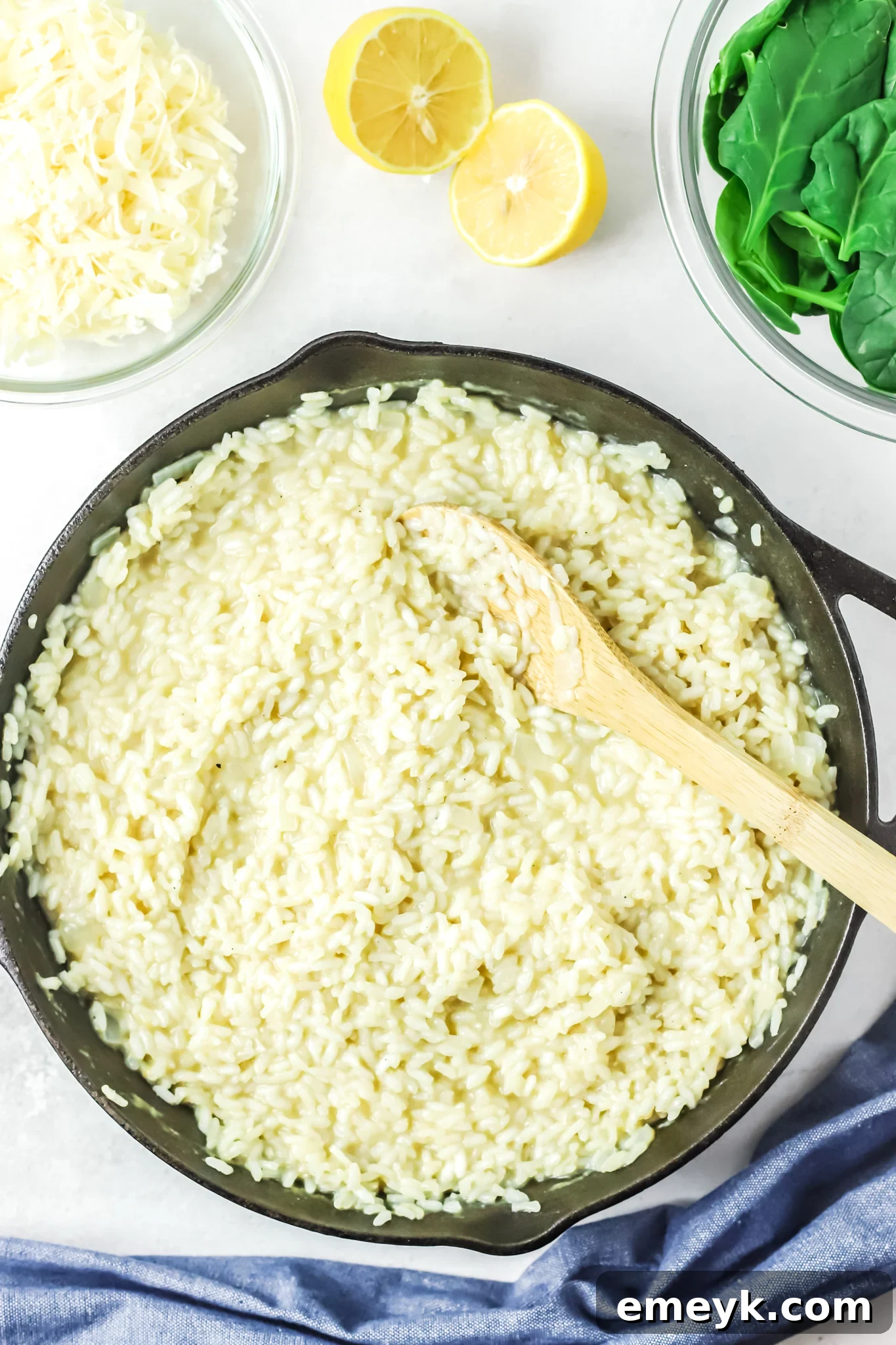 Creamy risotto cooking in a skillet, showcasing the absorption of broth and its thickening texture, a key component of Oven Baked Chicken Thighs with Risotto.