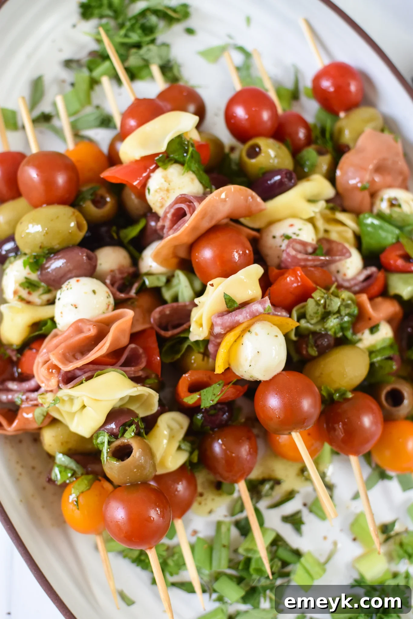 Antipasto Picks 2 Antipasto Skewers on a white platter, showcasing vibrant colors and fresh ingredients.
