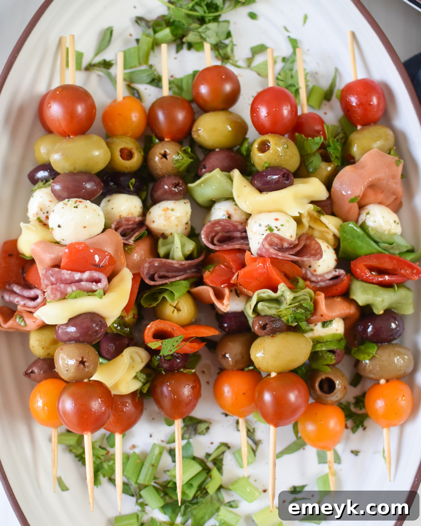 Antipasto Picks 7 Antipasto Skewers served on a elegant white plate, drizzled with balsamic glaze.