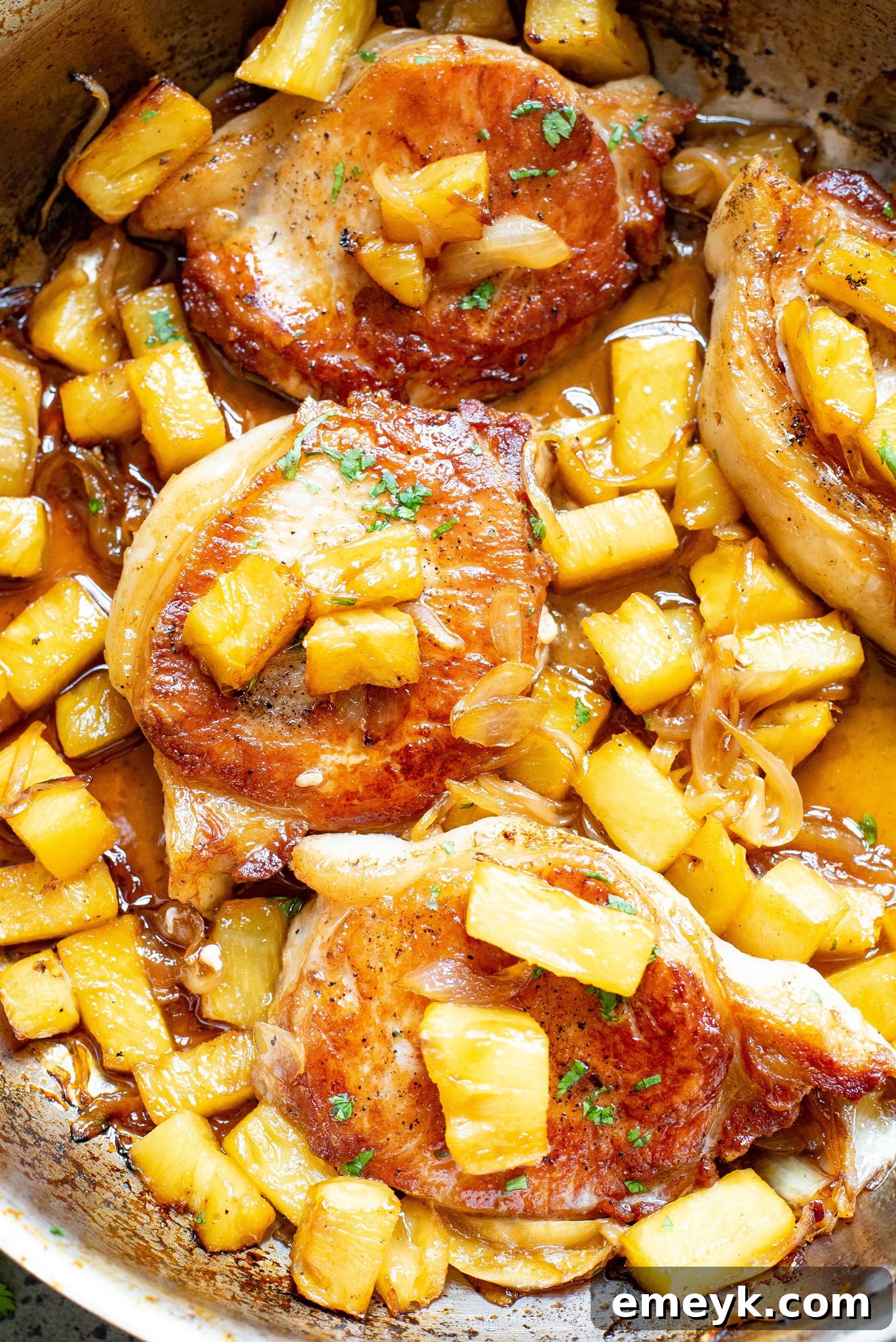 Close-up of a serving of pineapple pork chops, showcasing the tender pork, vibrant pineapple chunks, and the luscious sweet and sour sauce, ready for a delicious meal.