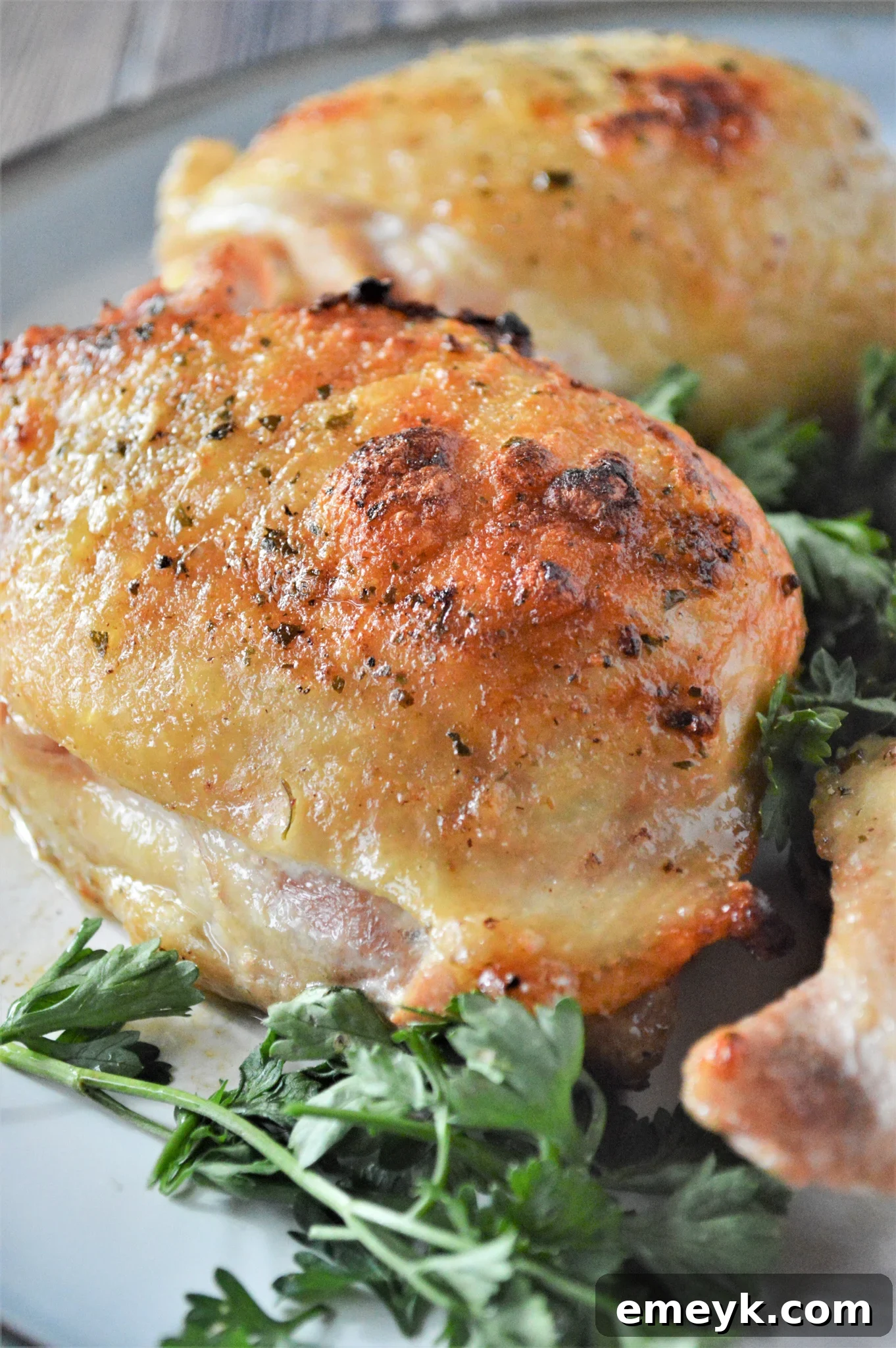 Creamy Ranch Chicken Thighs 4 Oven Baked Ranch Chicken Thighs on a plate with fresh greens, ready to be served.