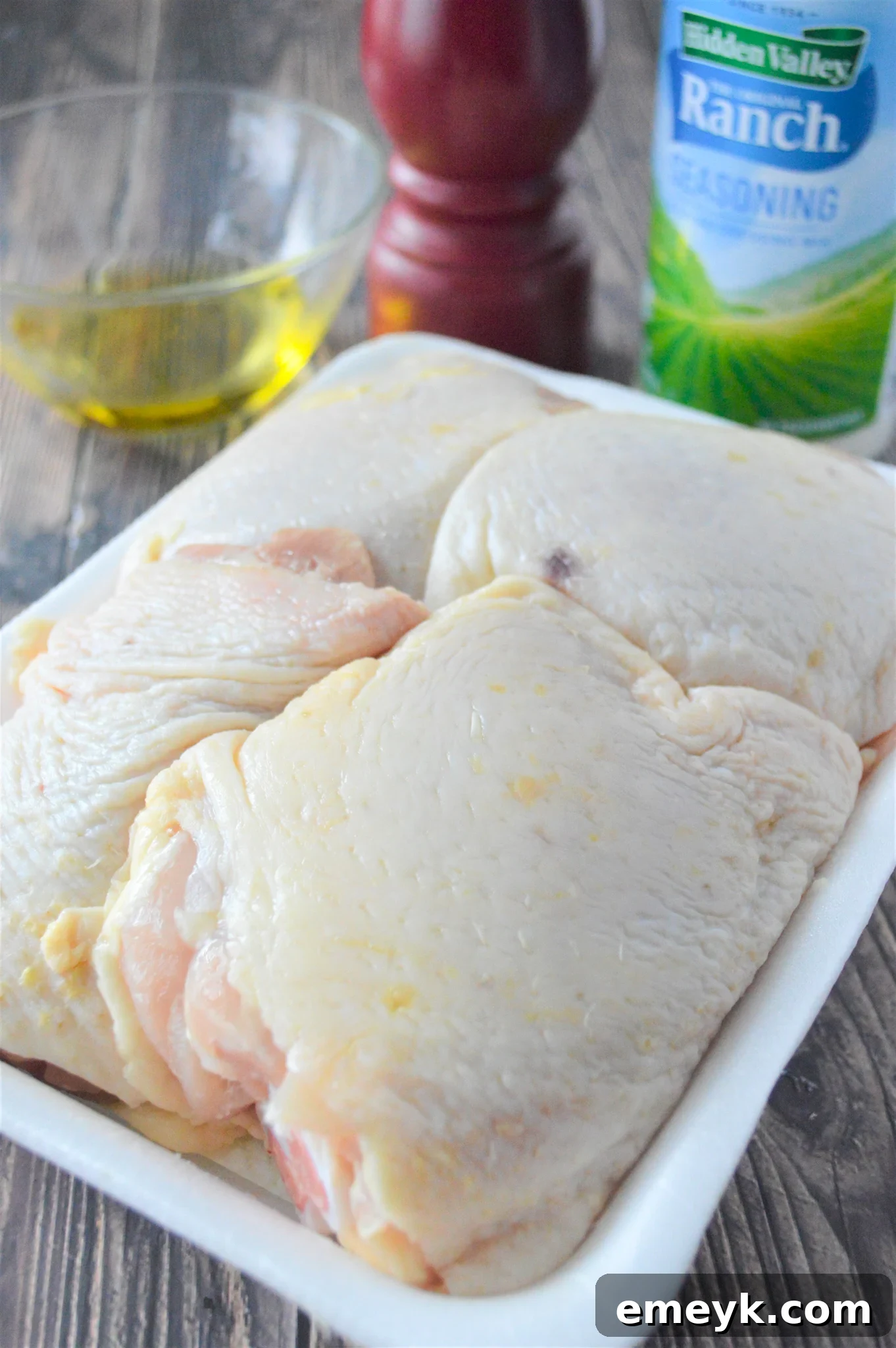 Creamy Ranch Chicken Thighs 5 Oven Baked Ranch Chicken Thighs chicken in a baking dish, coated in olive oil.