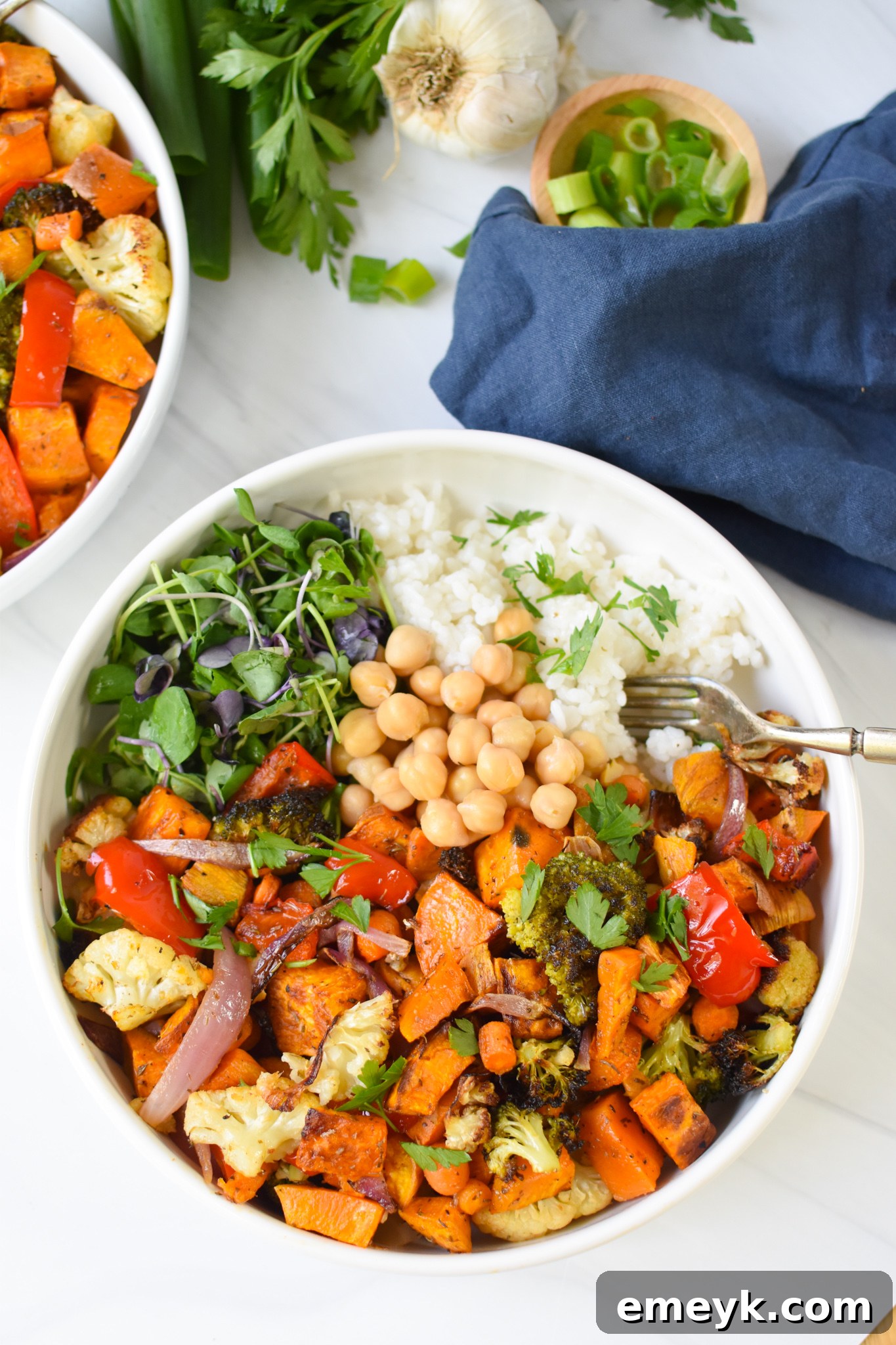 A close-up shot of a Sweet Potato Bowl with a fork, showing the texture of roasted vegetables, grains, and chickpeas, ready to be enjoyed.