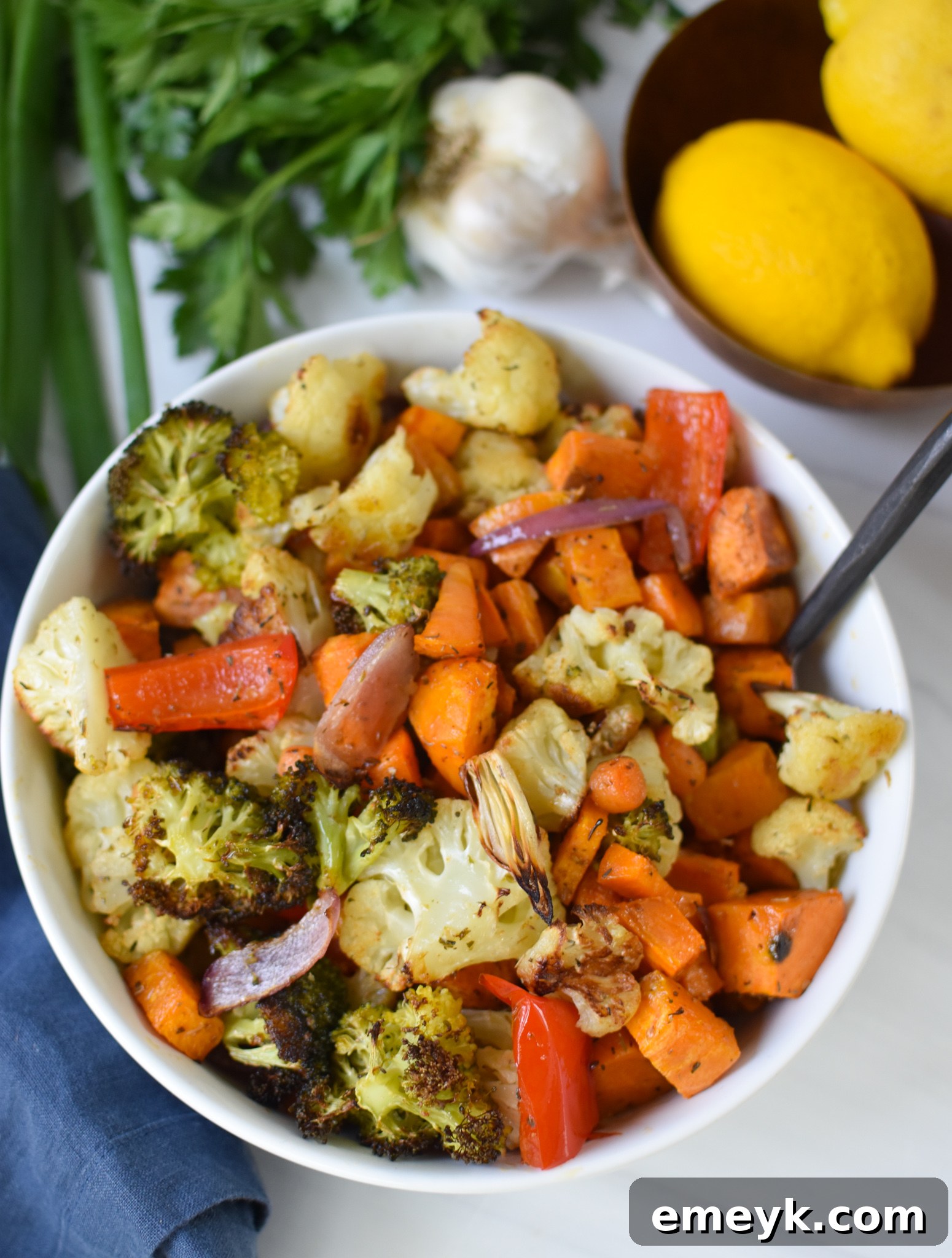 A bowl filled with roasted sweet potatoes and mixed vegetables, ready to be added to the grain bowls.