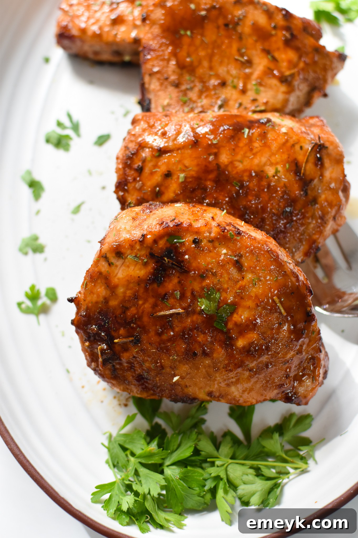 Platter of Air Fryer Boneless Pork Chops garnished with fresh herbs.