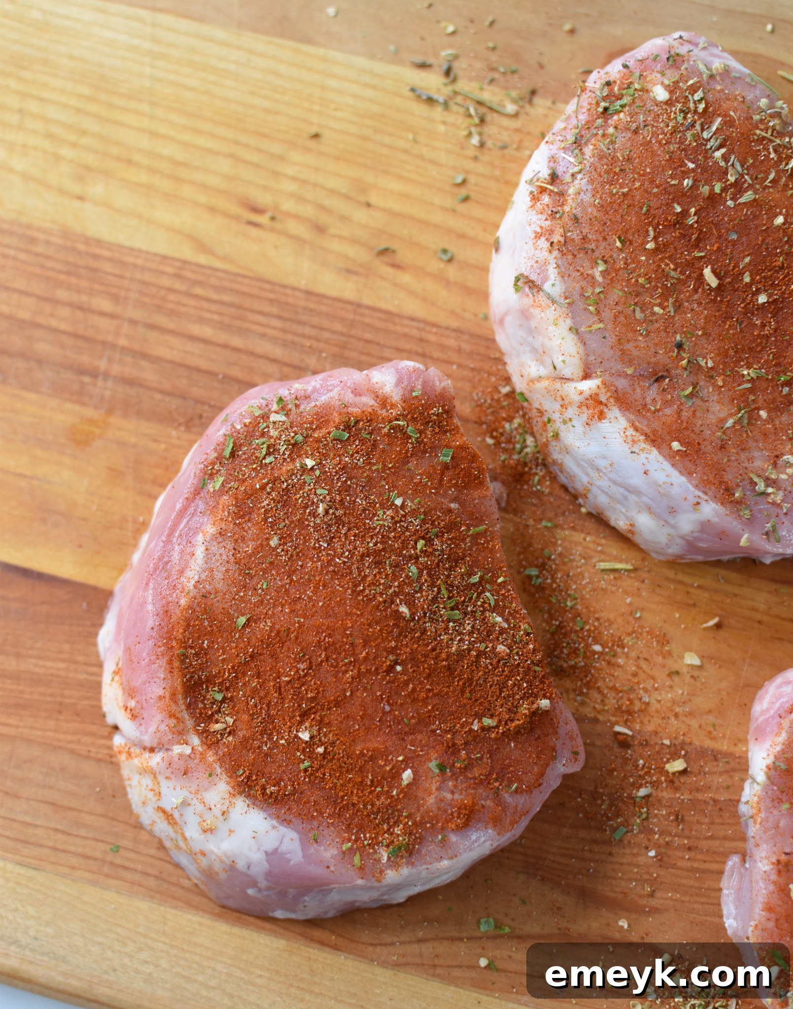 Air Fryer Boneless Pork Chops in the basket, coated in spices.