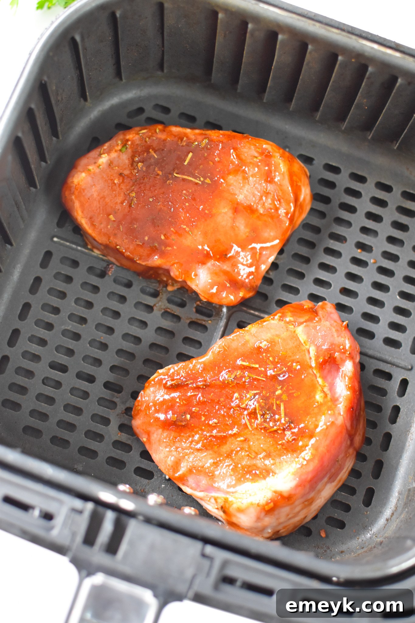Cooked Air Fryer Boneless Pork Chops being brushed with more BBQ sauce.