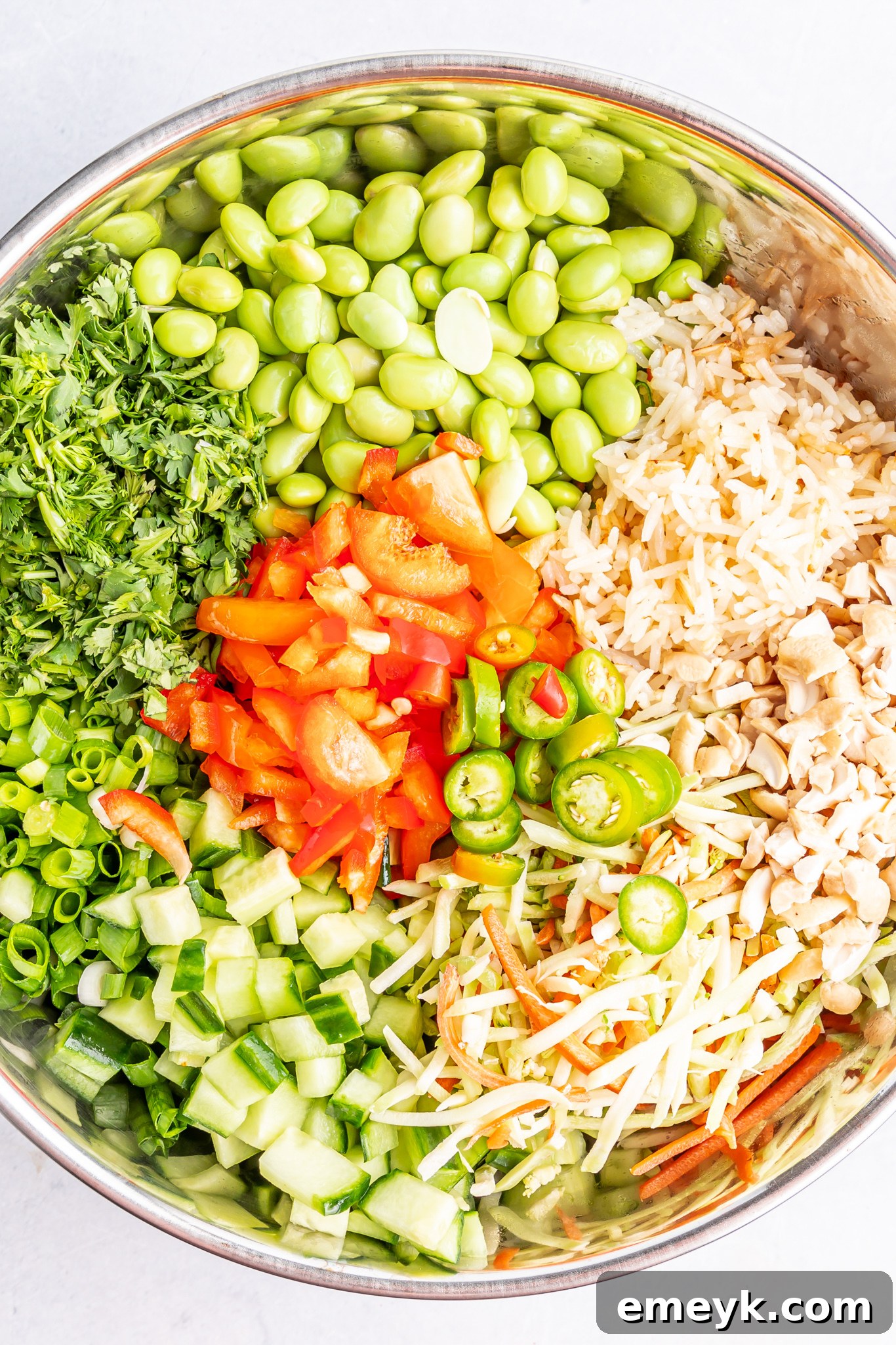 A close-up of Coconut Rice Salad ingredients in a bowl, showcasing fresh vegetables and fluffy rice.