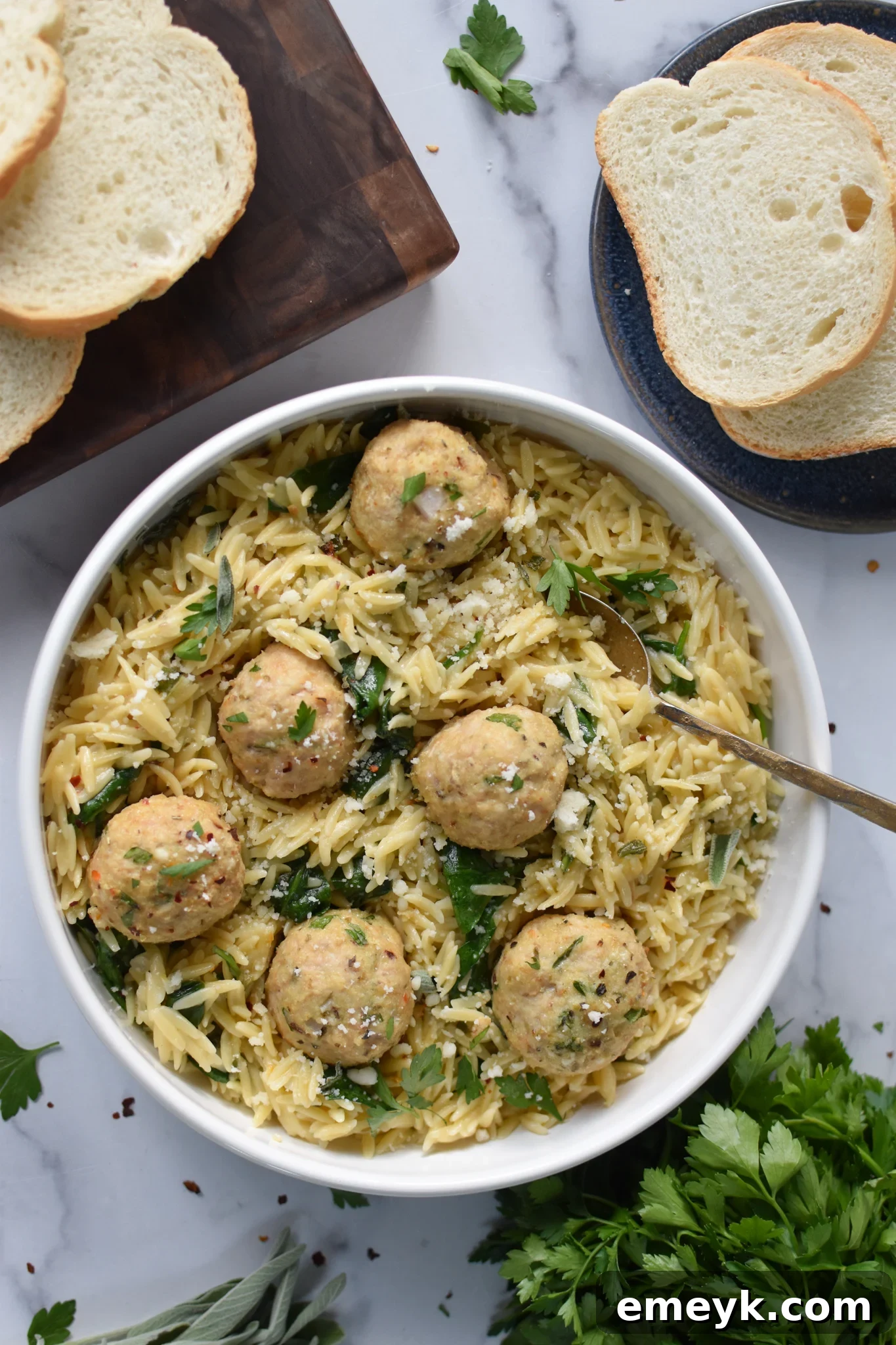 Baked Chicken Meatballs with a fork in a white bowl. A visually appealing dish for any occasion.