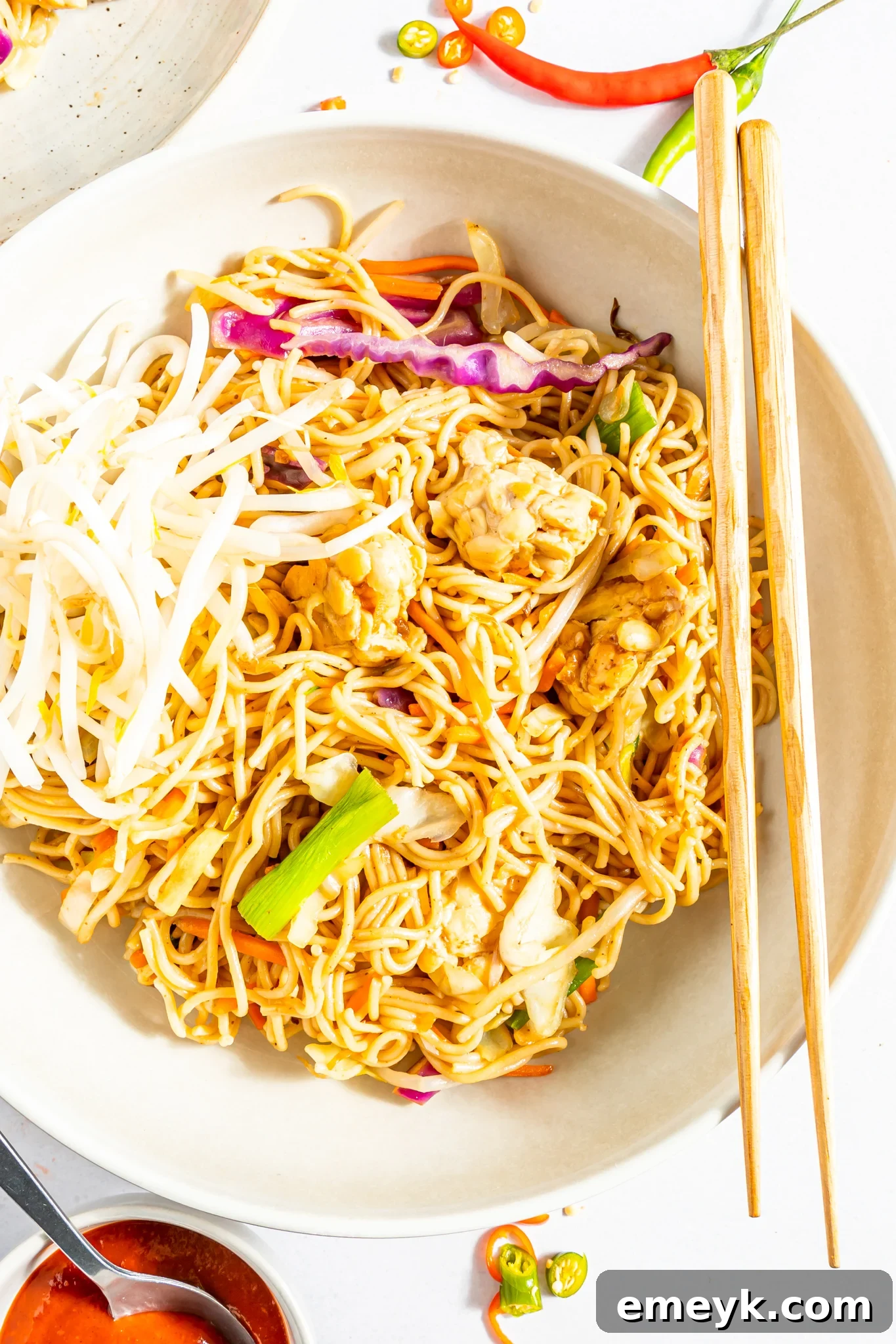 Wholesome Weeknight Veggie Chow Mein 4 Easy Vegetable Chow Mein being served into a bowl using chopsticks, highlighting the texture and freshness of the ingredients.