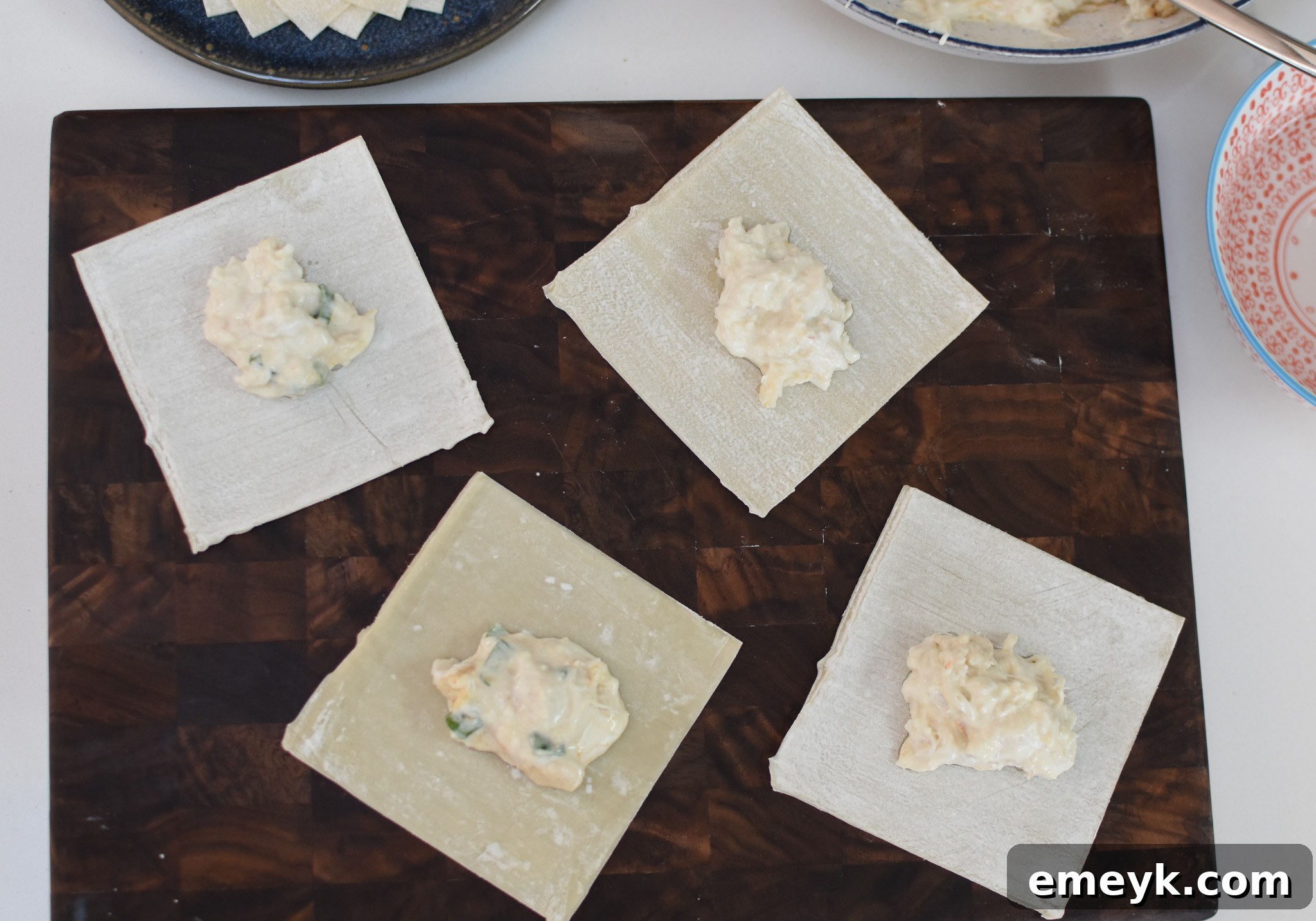 A wonton wrapper with a dollop of crab mixture in the center, ready to be folded.