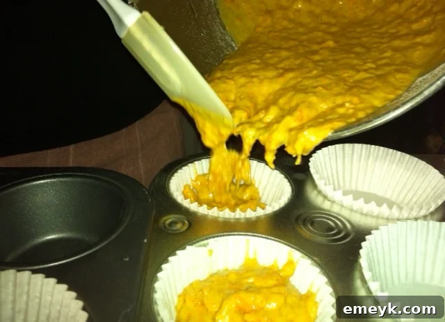 Filling cupcake liners with rich, spiced carrot cake batter