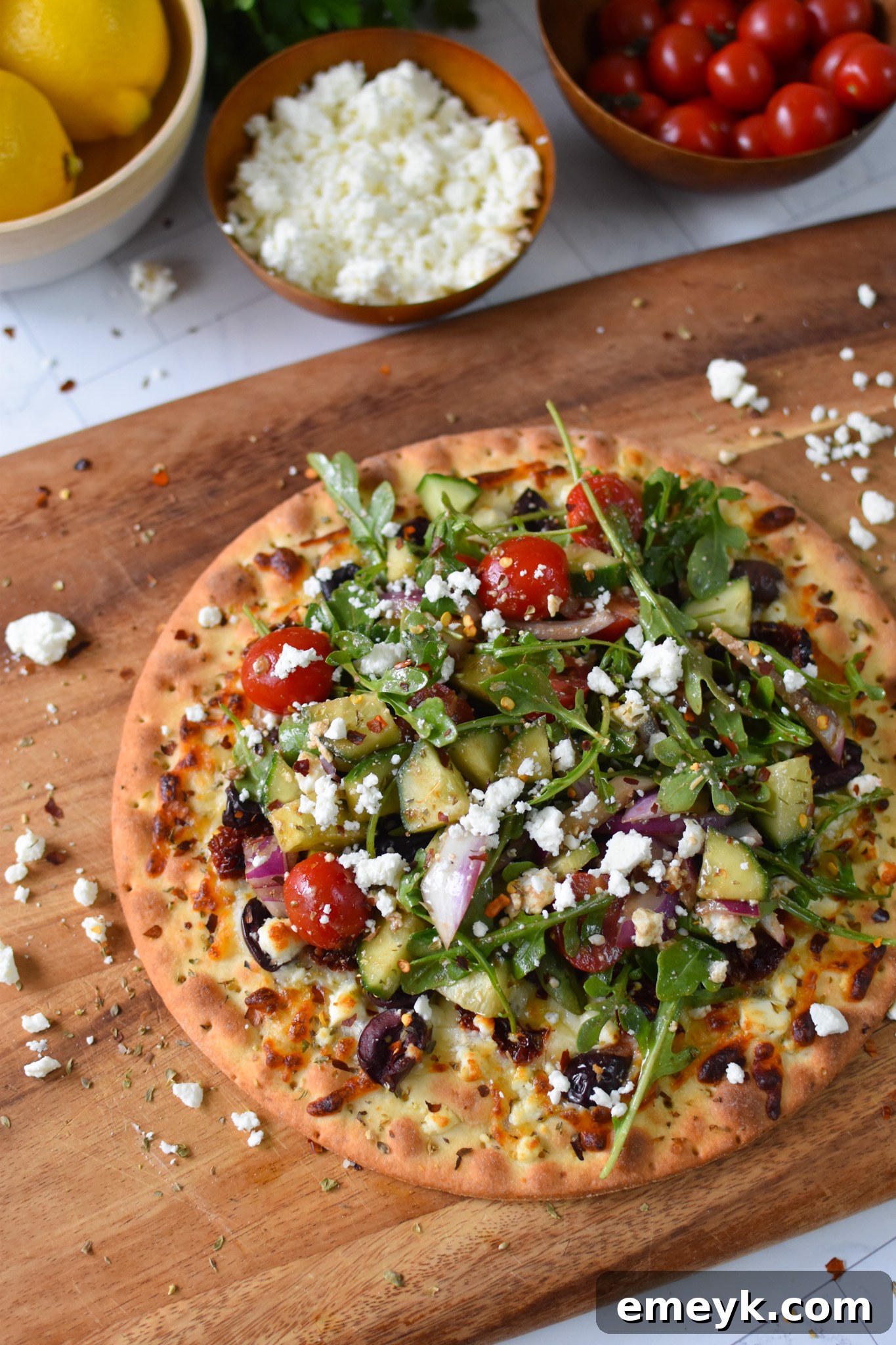 Hellenic Pizza 2 Greek Pizza with fresh arugula topping, ready to be served on a wooden board.