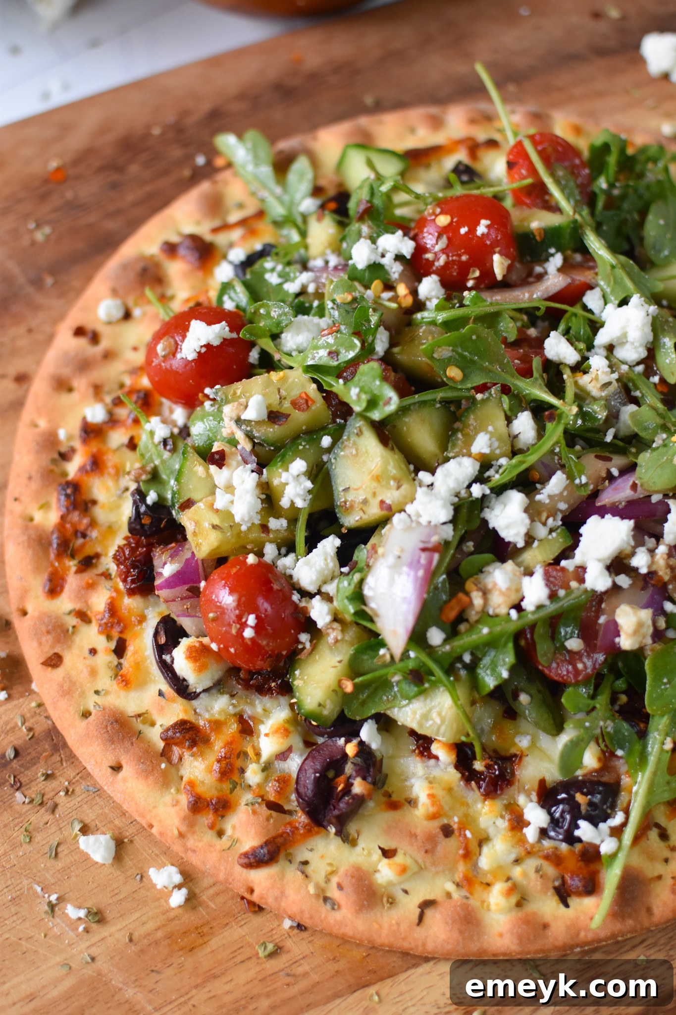 Hellenic Pizza 7 Close-up of Greek Pizza, showing the vibrant toppings and salad.