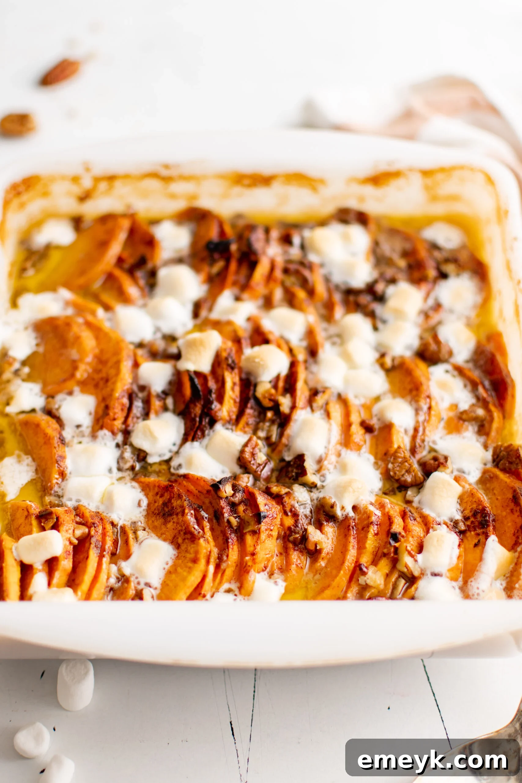 Easy Scalloped Sweet Potatoes baking in a white casserole dish.