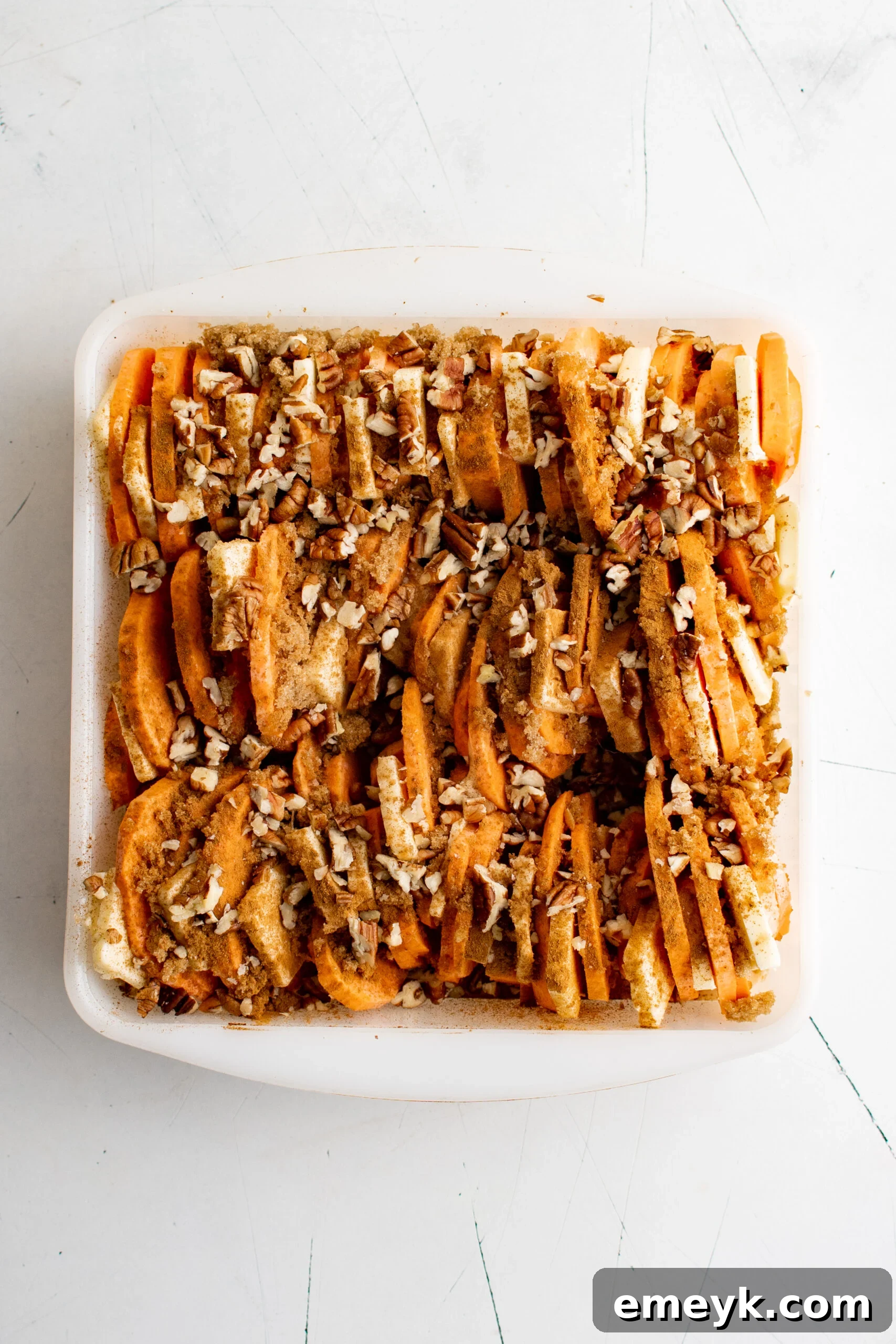 Easy Scalloped Sweet Potatoes with pecans sprinkled on top.