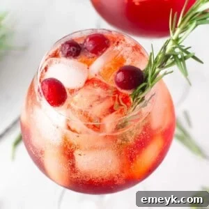 Cranberry Aperol Spritz in a glass, ready to drink, with a festive background.